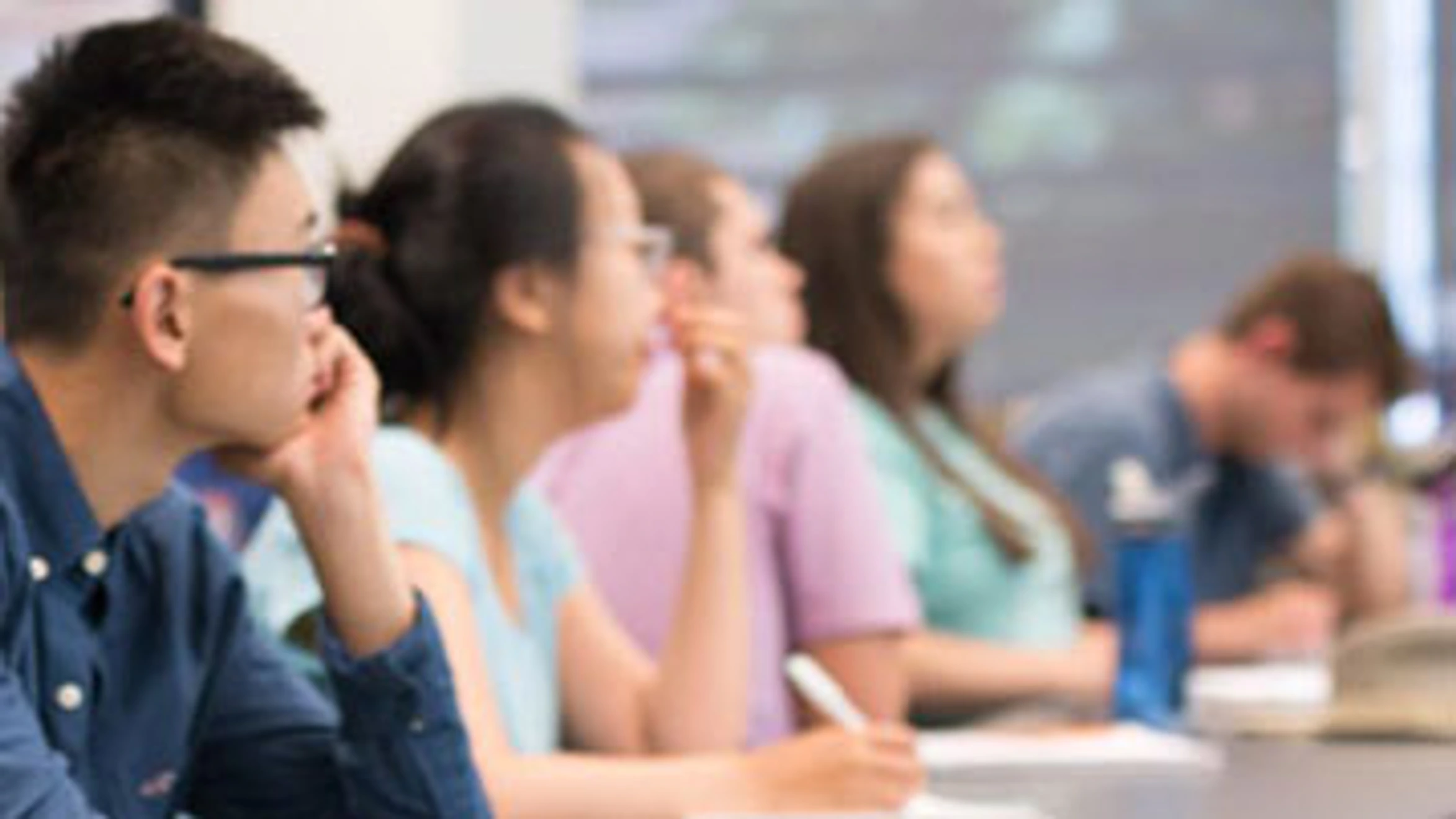 a group of students sitting at desks in a classroom.