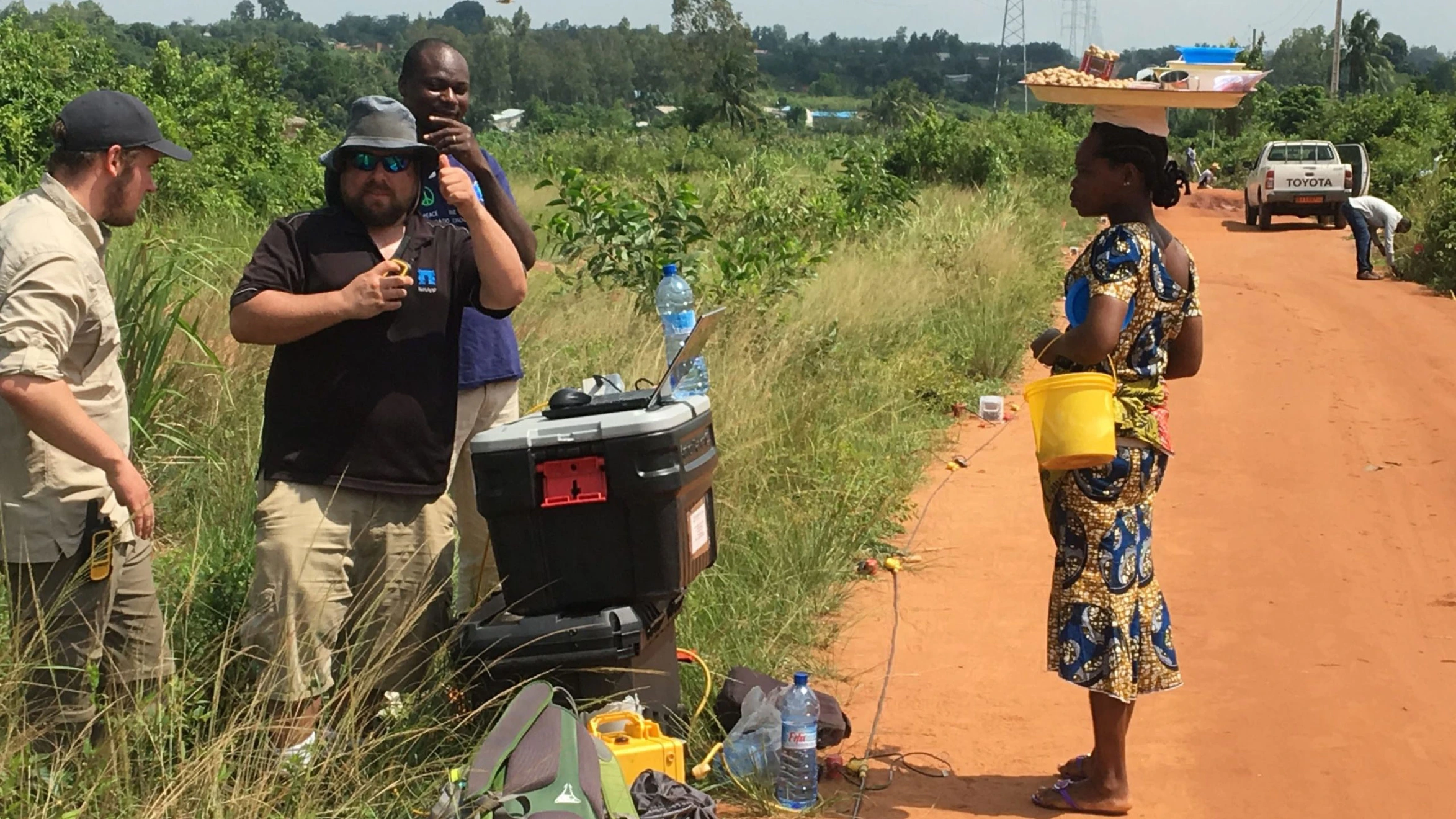 A group of people standing on a dirt road.