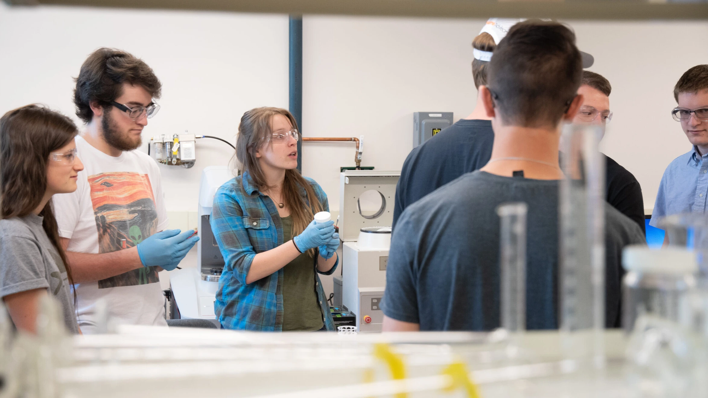 A group of people standing around a table in a lab.