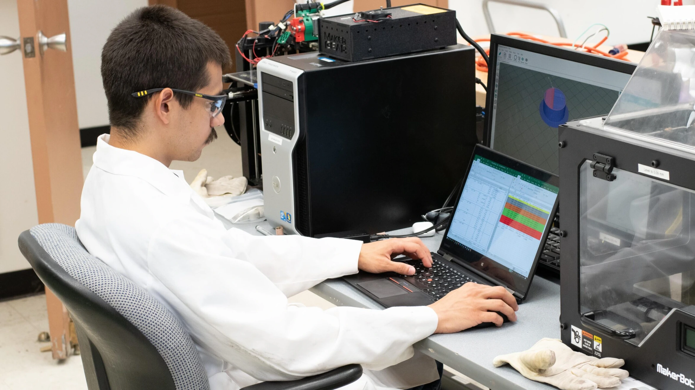 A man sitting at a desk using a laptop computer.