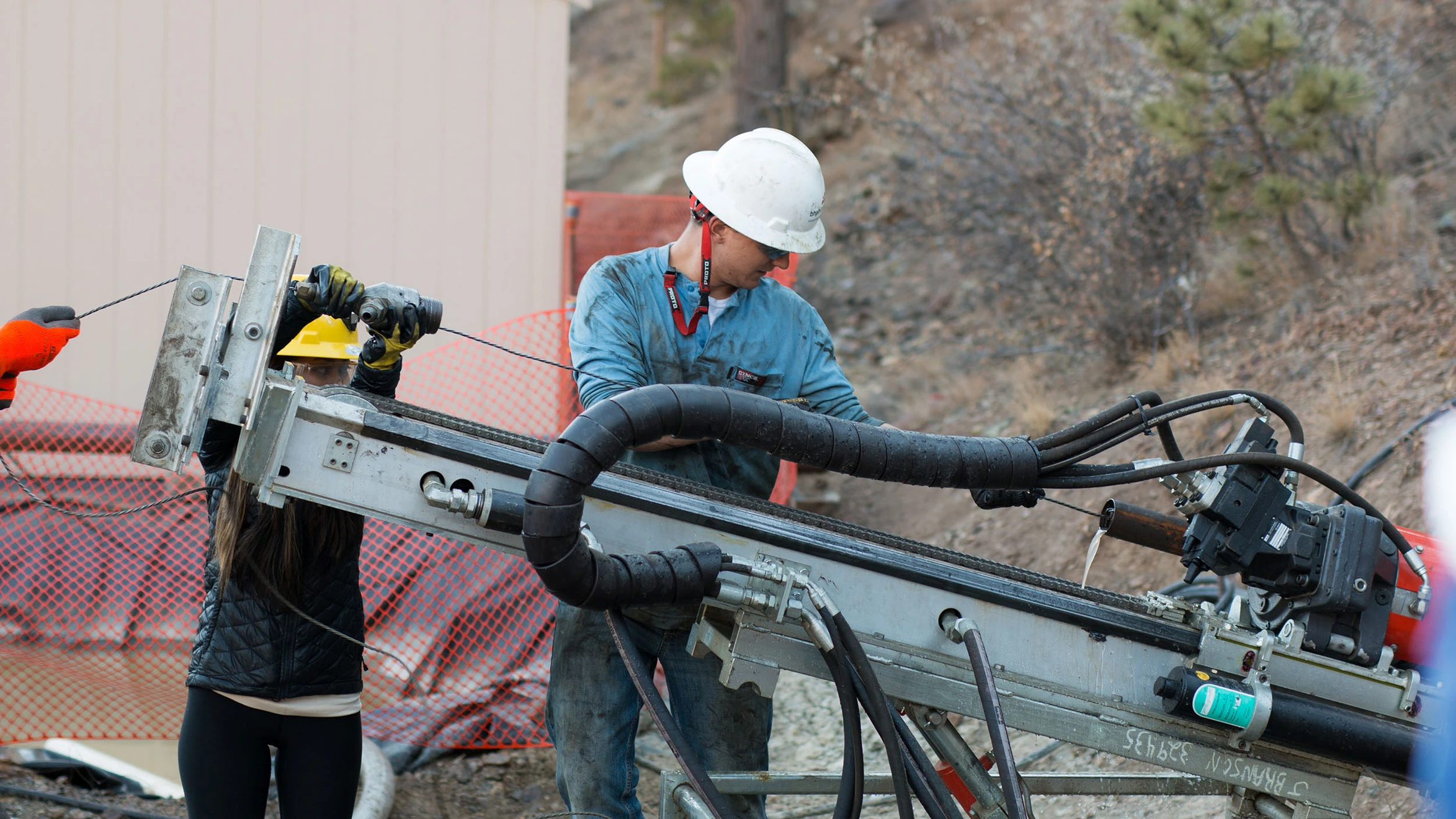 A man and a woman working on a drilling rig.