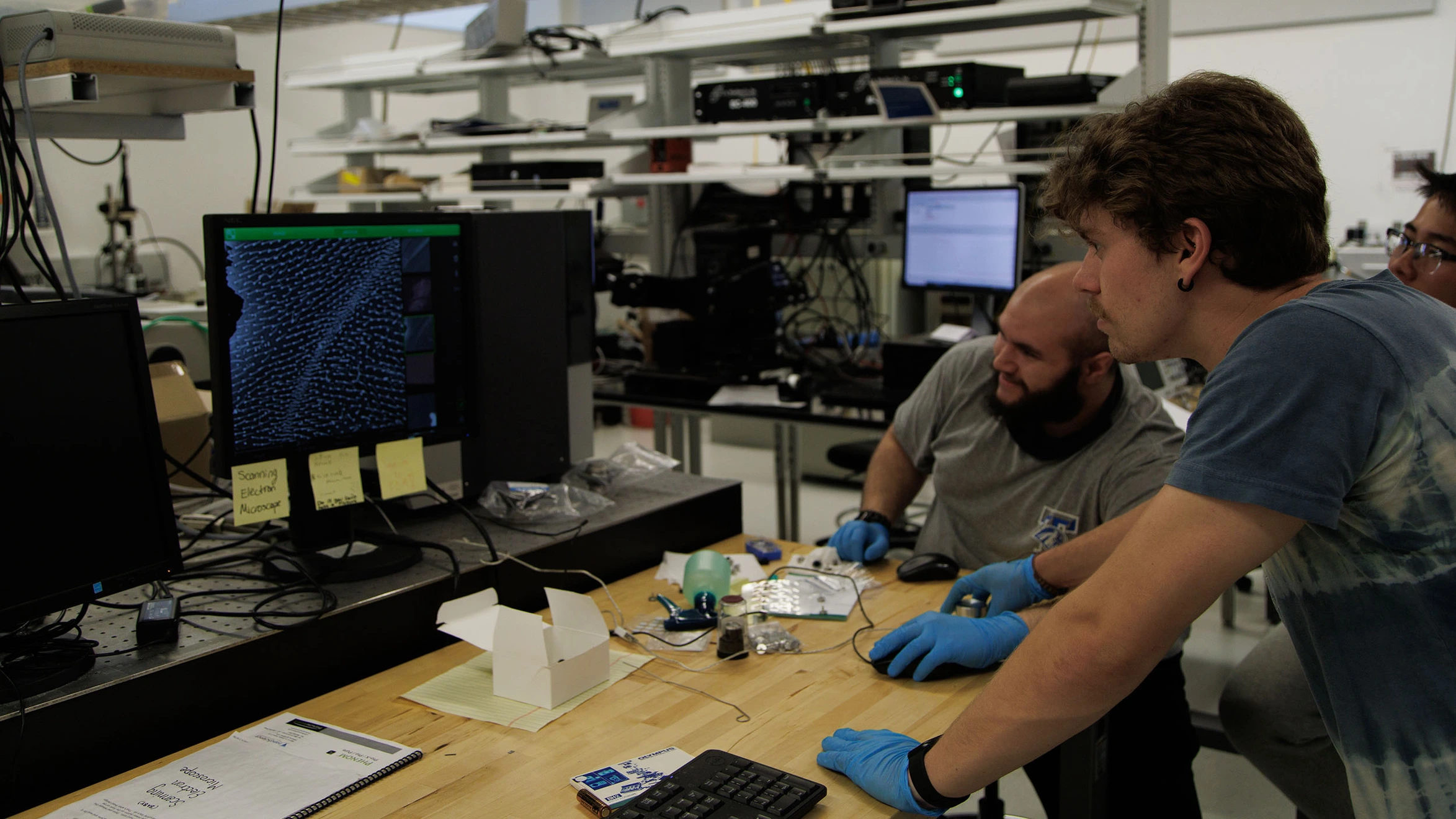 A group of men working on a computer in a lab.