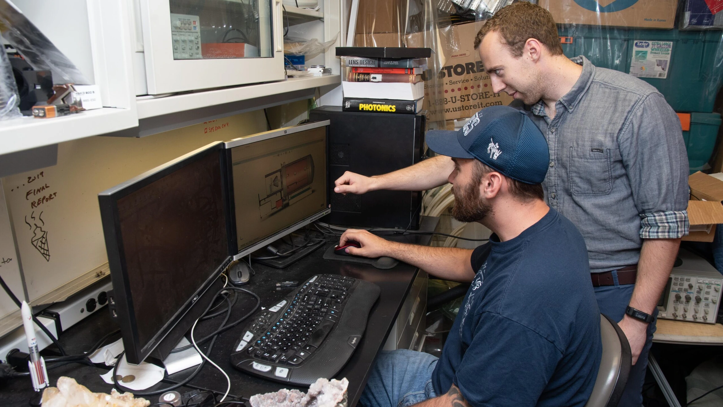 Two men looking at a computer screen in a lab.