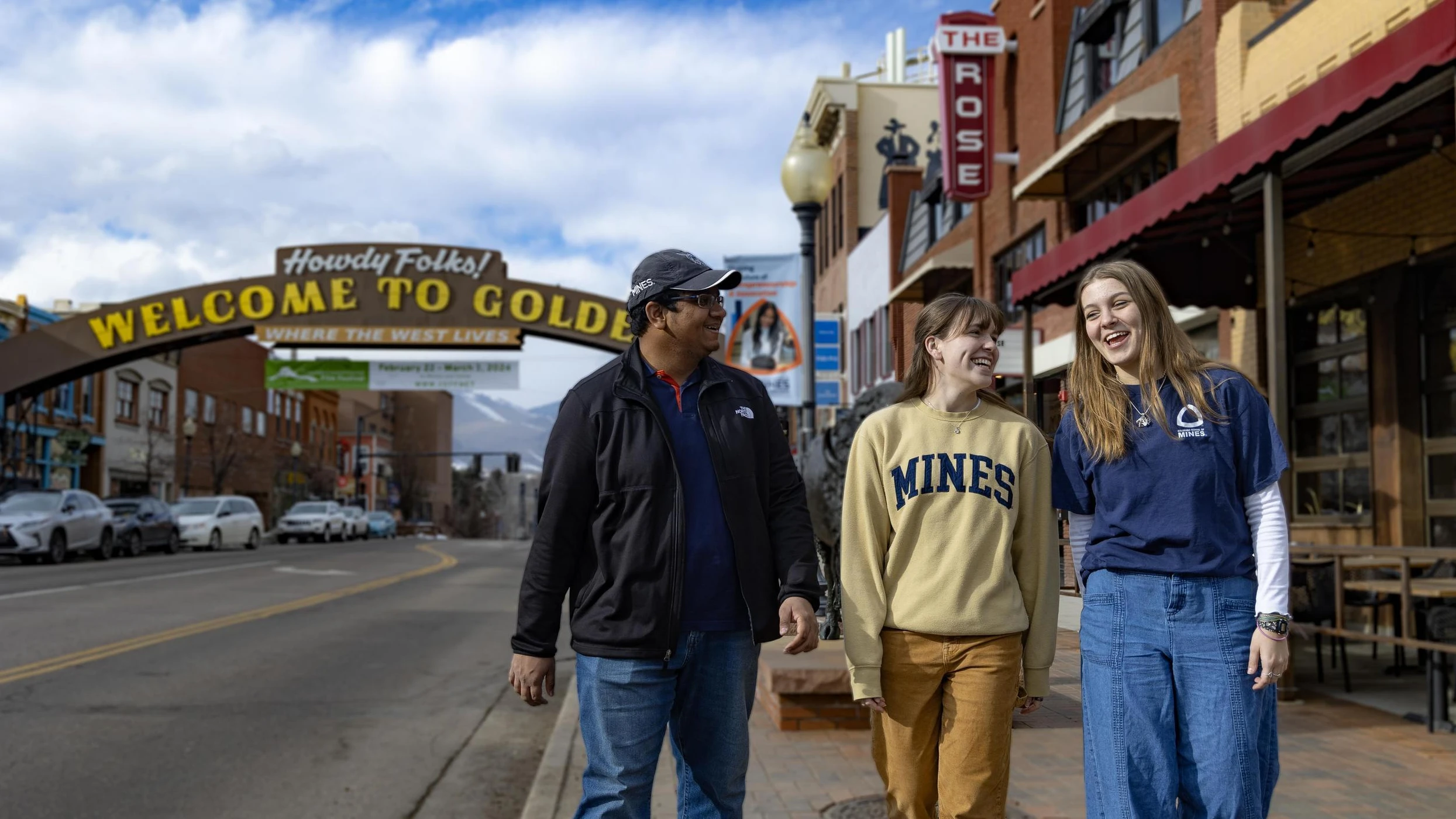 Three Mines students walking and laughing on a street under a 