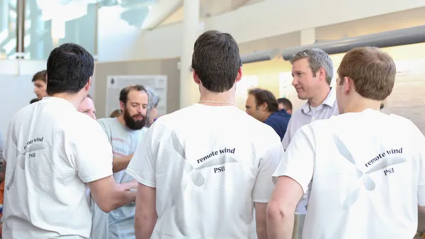 A group of men in white shirts talking to each other.