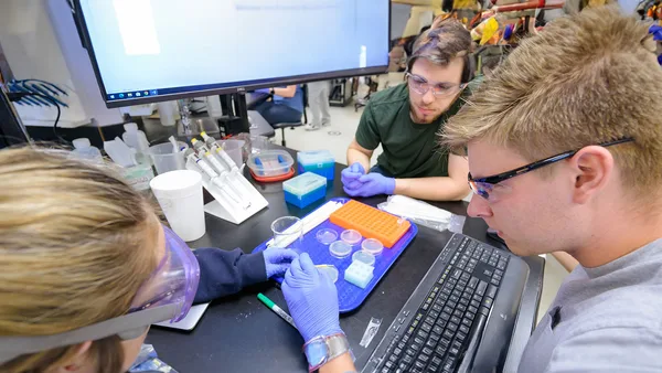 A group of people working in a lab with a computer.