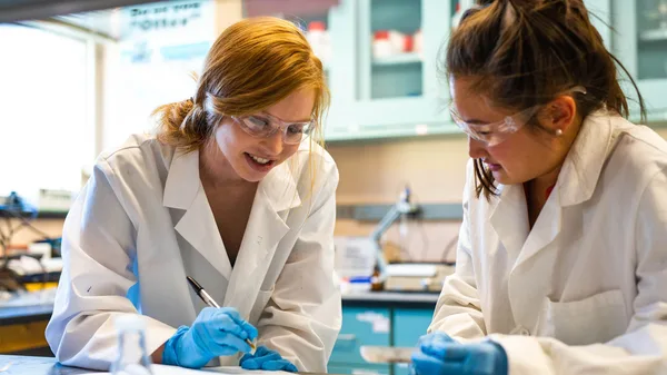Two women in lab coats working in a laboratory.