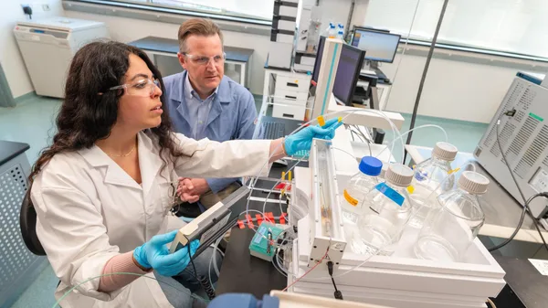 A man and a woman in lab coats working in a laboratory.