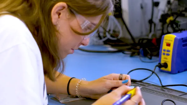 A woman in a lab coat working on a computer.