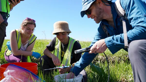 A group of people in a field looking at something.