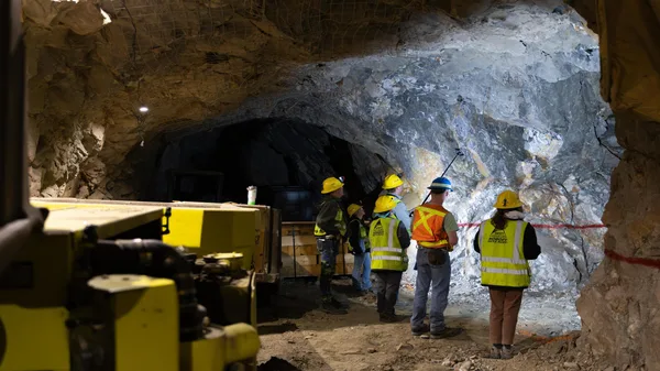 A group of construction workers standing in a tunnel.