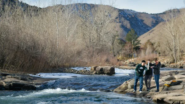 A group of people standing on rocks in a river.