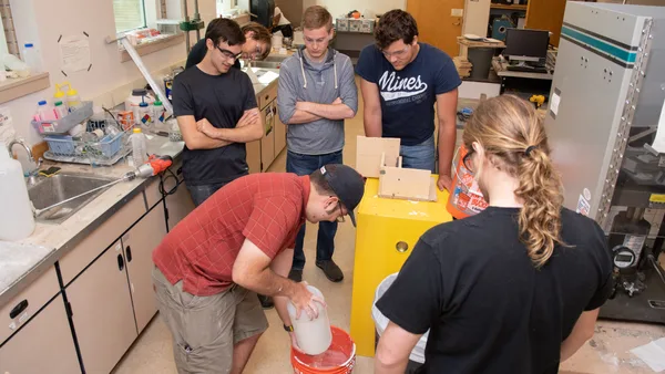 A group of people standing around a table in a lab.