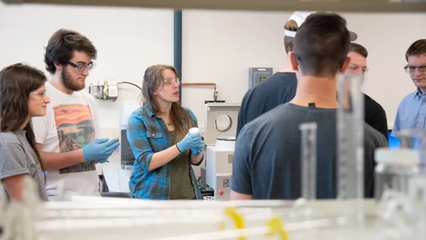 A group of people standing around a table in a lab.