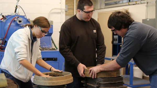 A group of three people working in a factory.