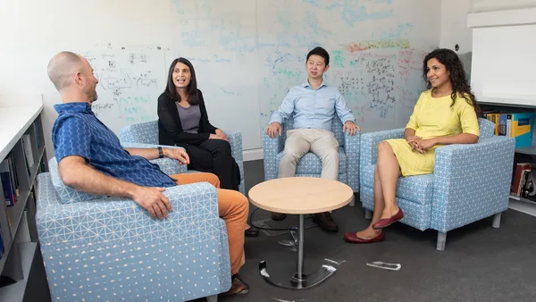 A group of people sitting around a table in a room.