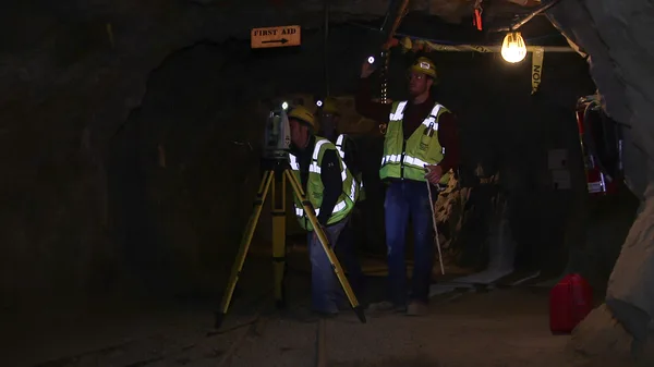 A group of men standing in a dark tunnel.