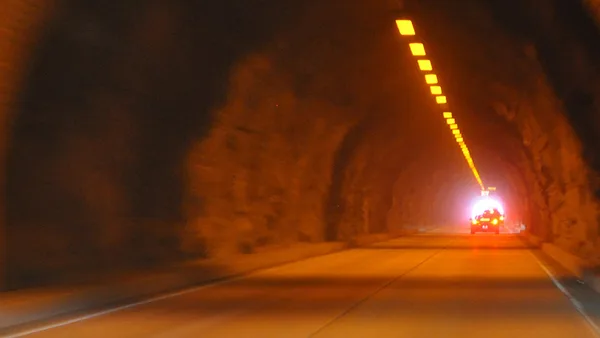 A car driving through a tunnel at night.