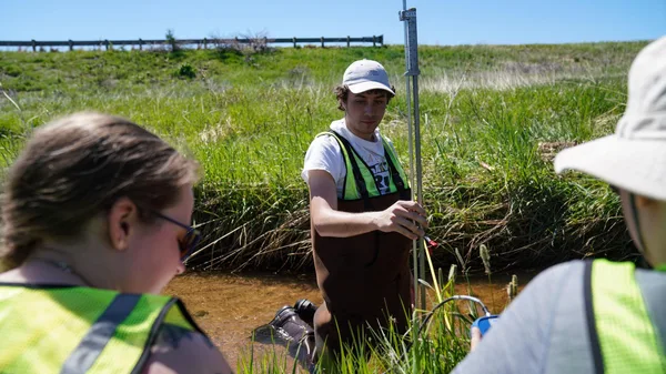 Mines Environmental Engineering students capture data in a stream at Chatfield Reservoir.