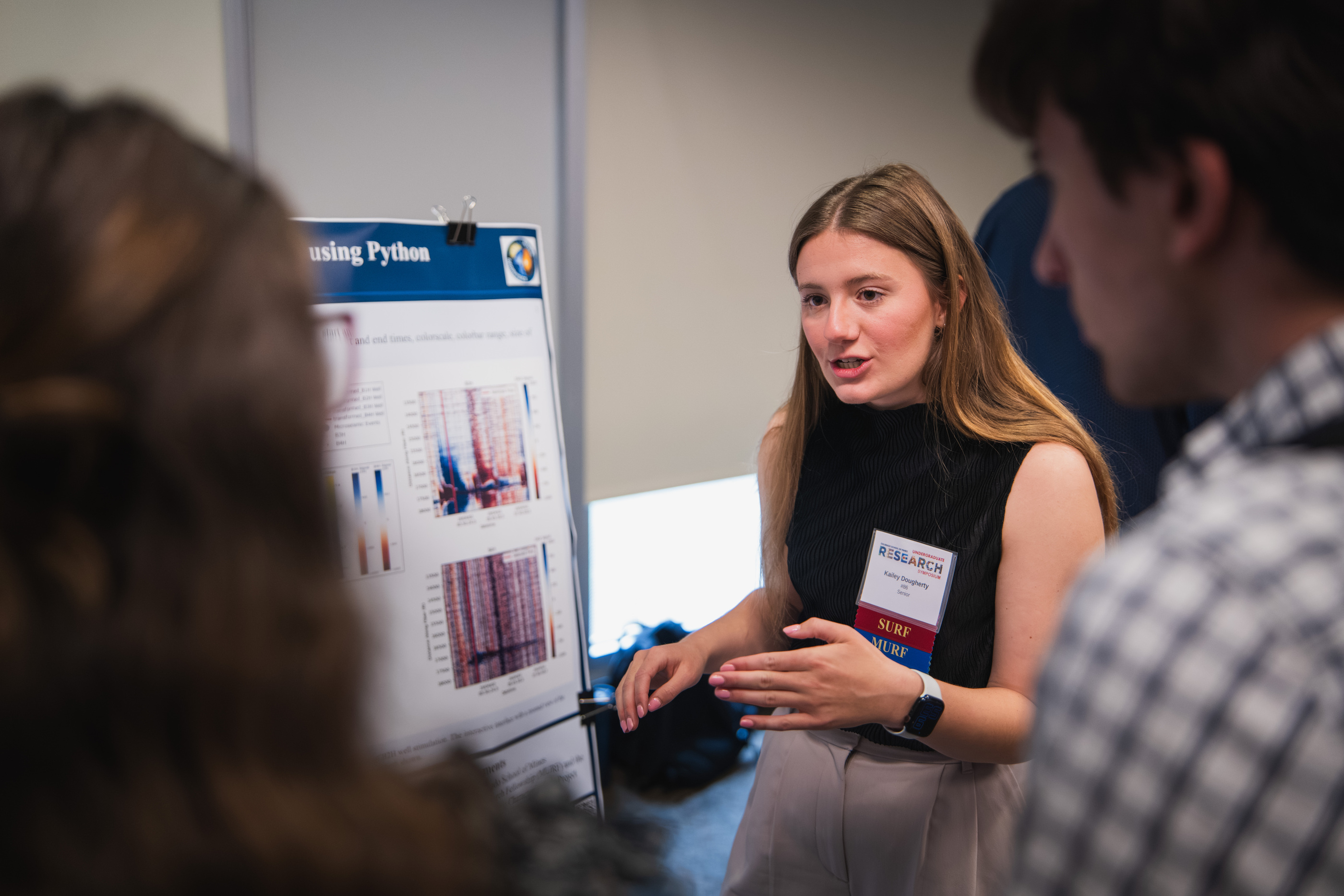Female student presents her research presentation to a group, actively discussing ideas as the audience engages