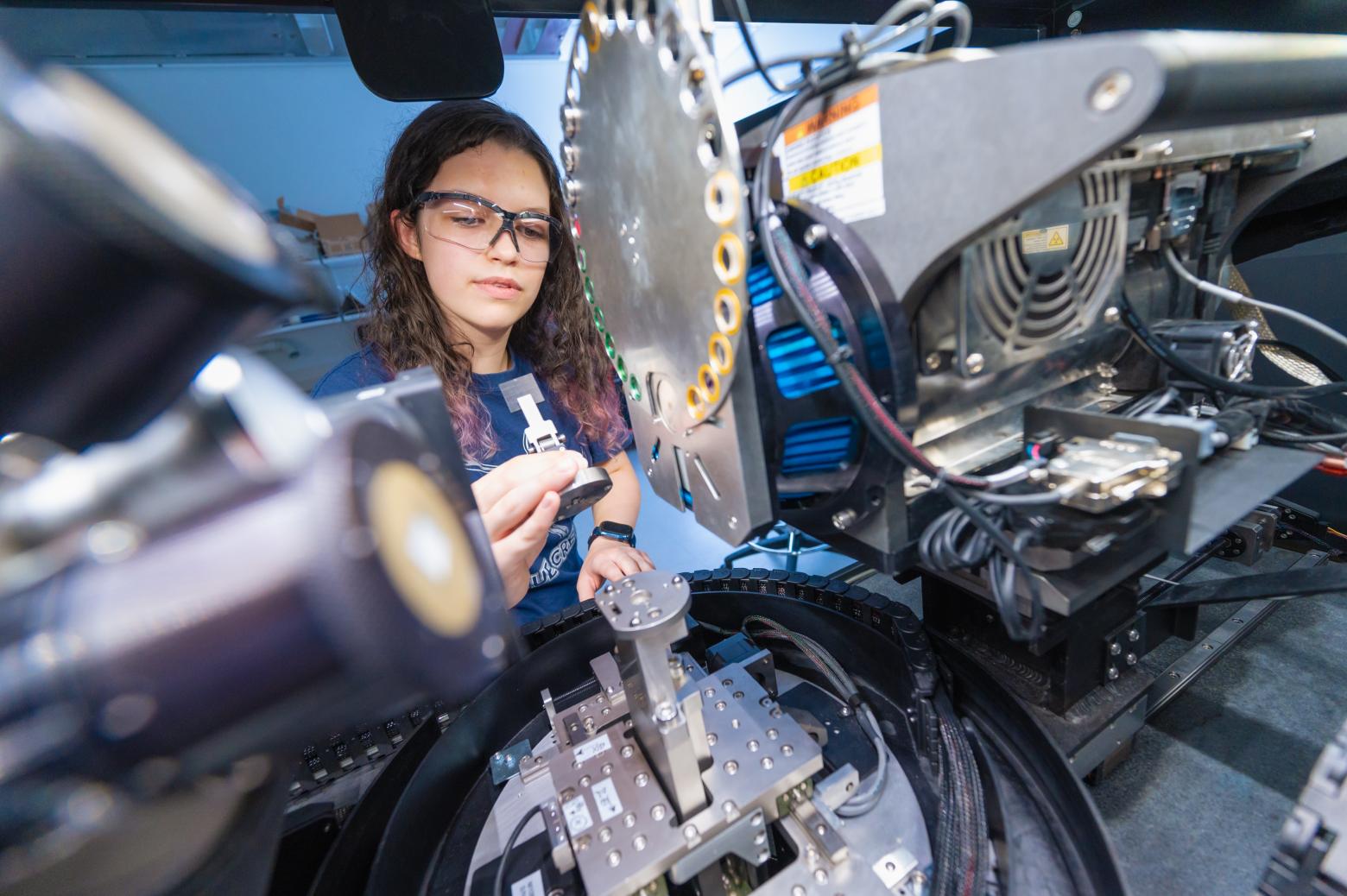 Meredith Amrhein places a sample in the Zeiss 520 Versa X-ray Computed Tomography Microscope