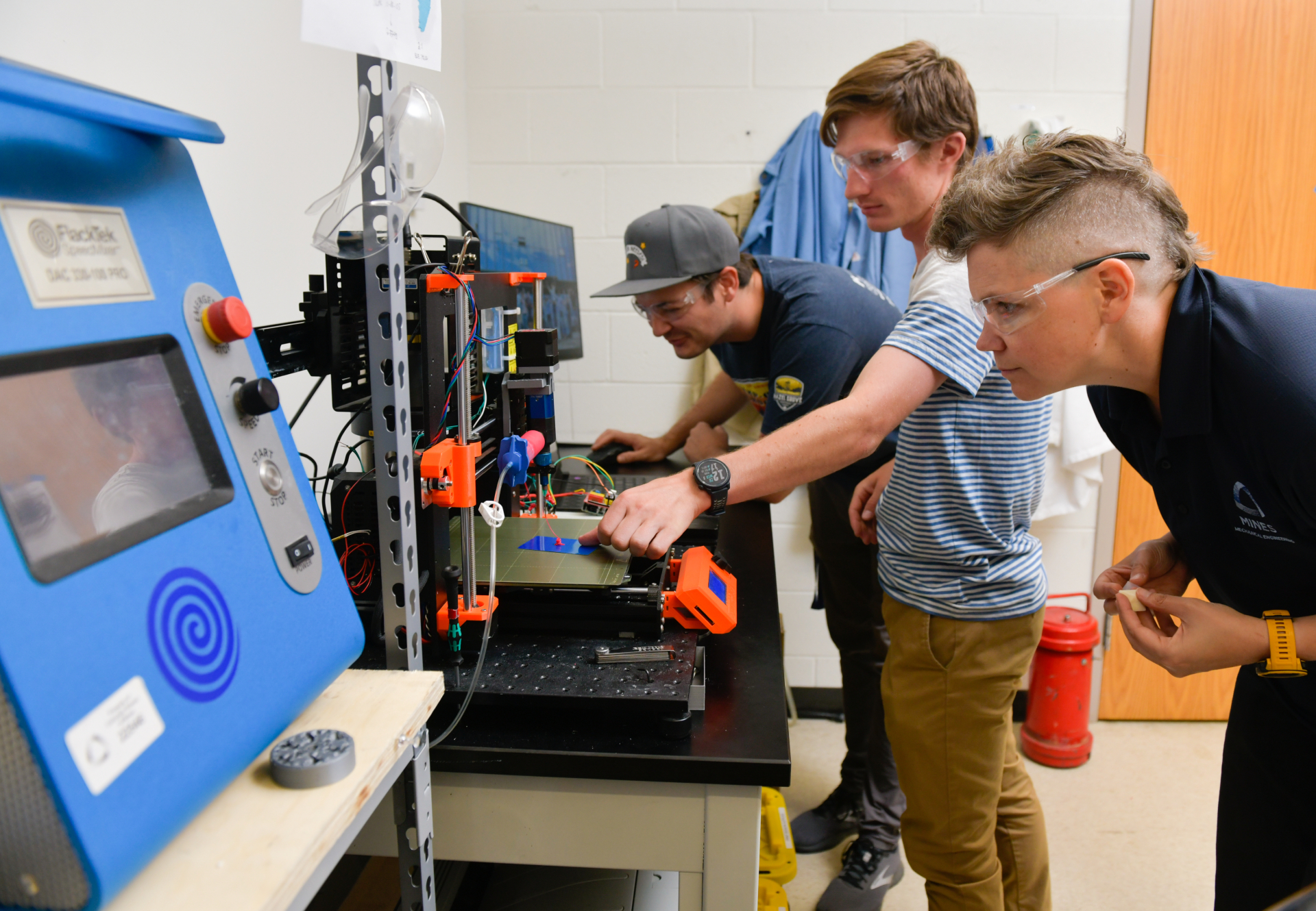 Dr. Eliasson works with two students at a 3d printer