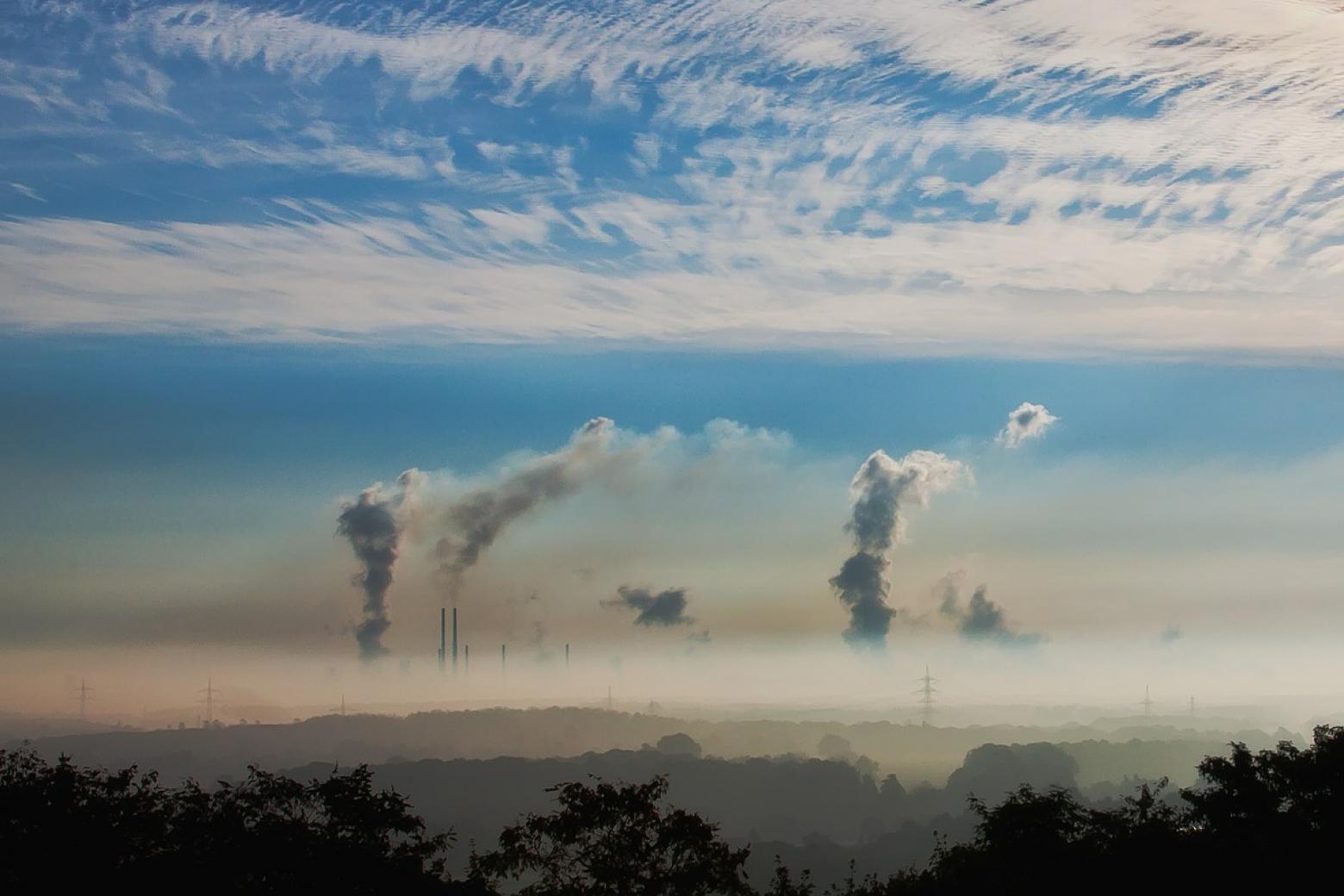 emissions from multiple smokestacks against a blue sky