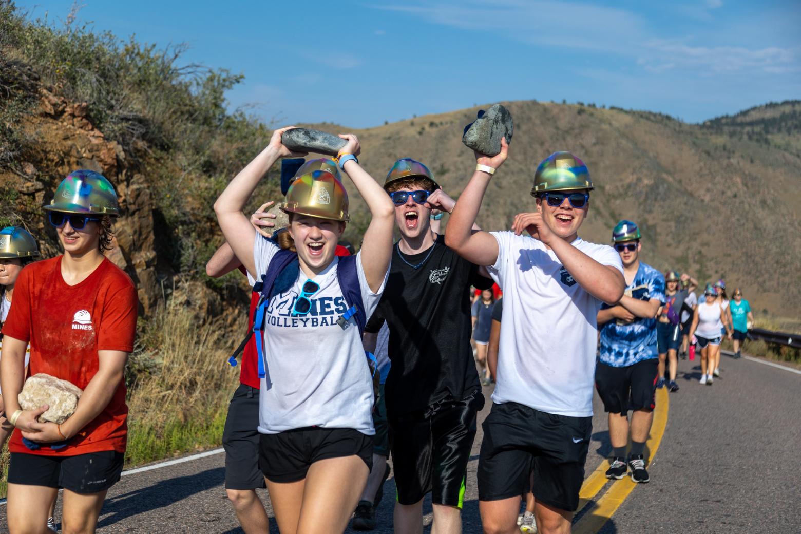 New Mines students hike up Mt. Zion in Golden, Colorado, hefting 10-pound rocks from their hometowns to place on the M on the mountain.
