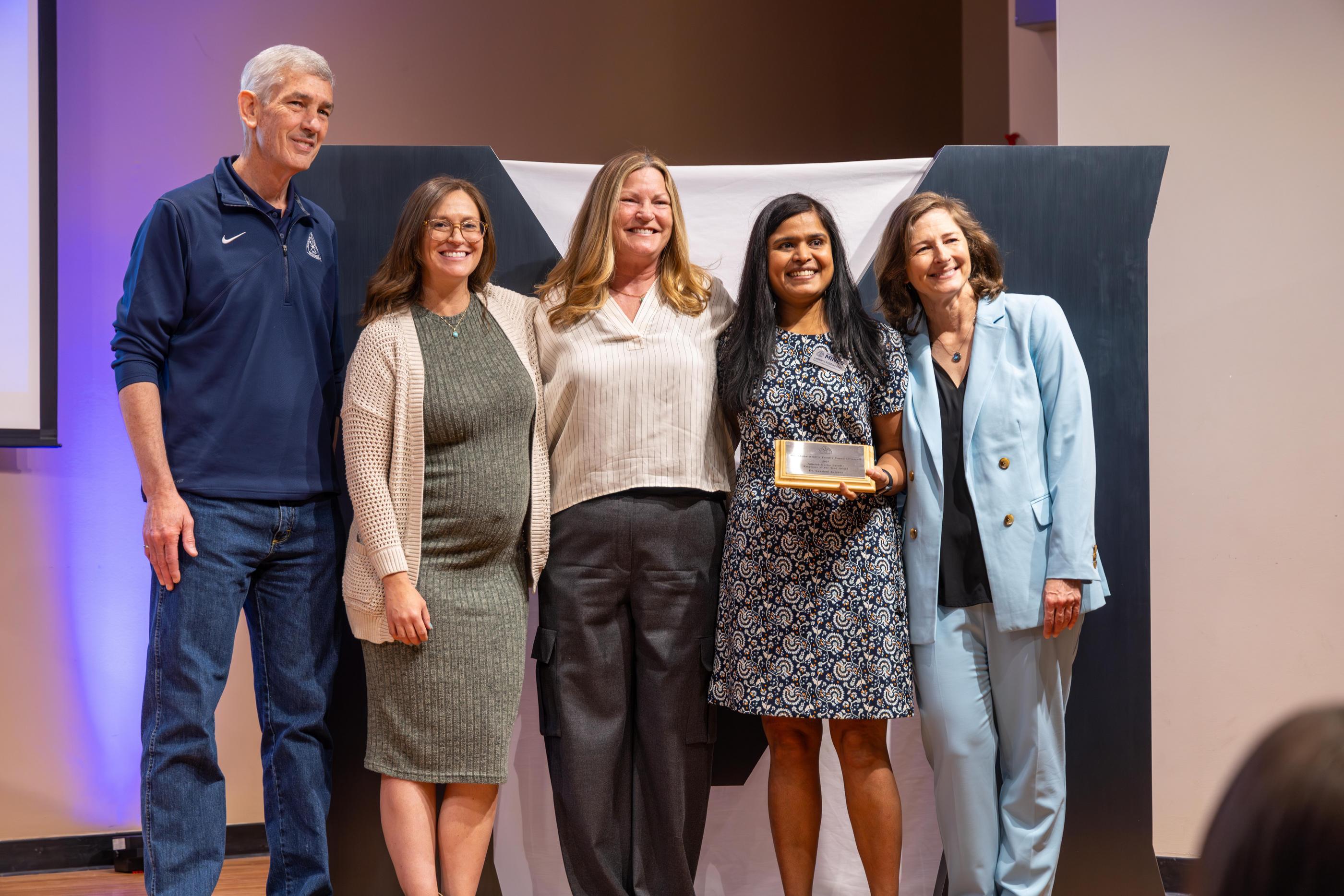 Group of Mines employees stand with President Johnson and hold award