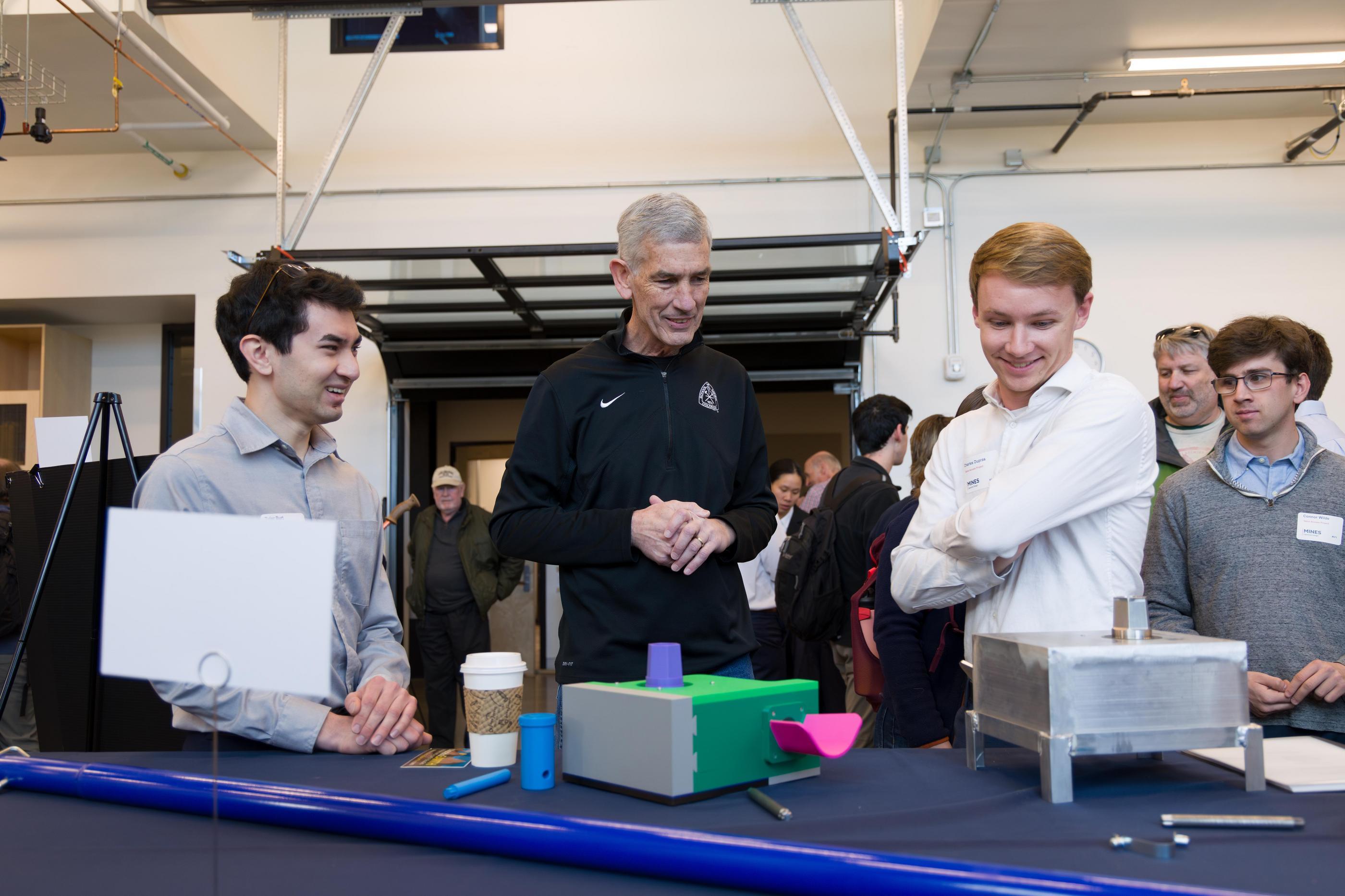 Two students present their Capstone Design project to Mines President Paul C Johnson