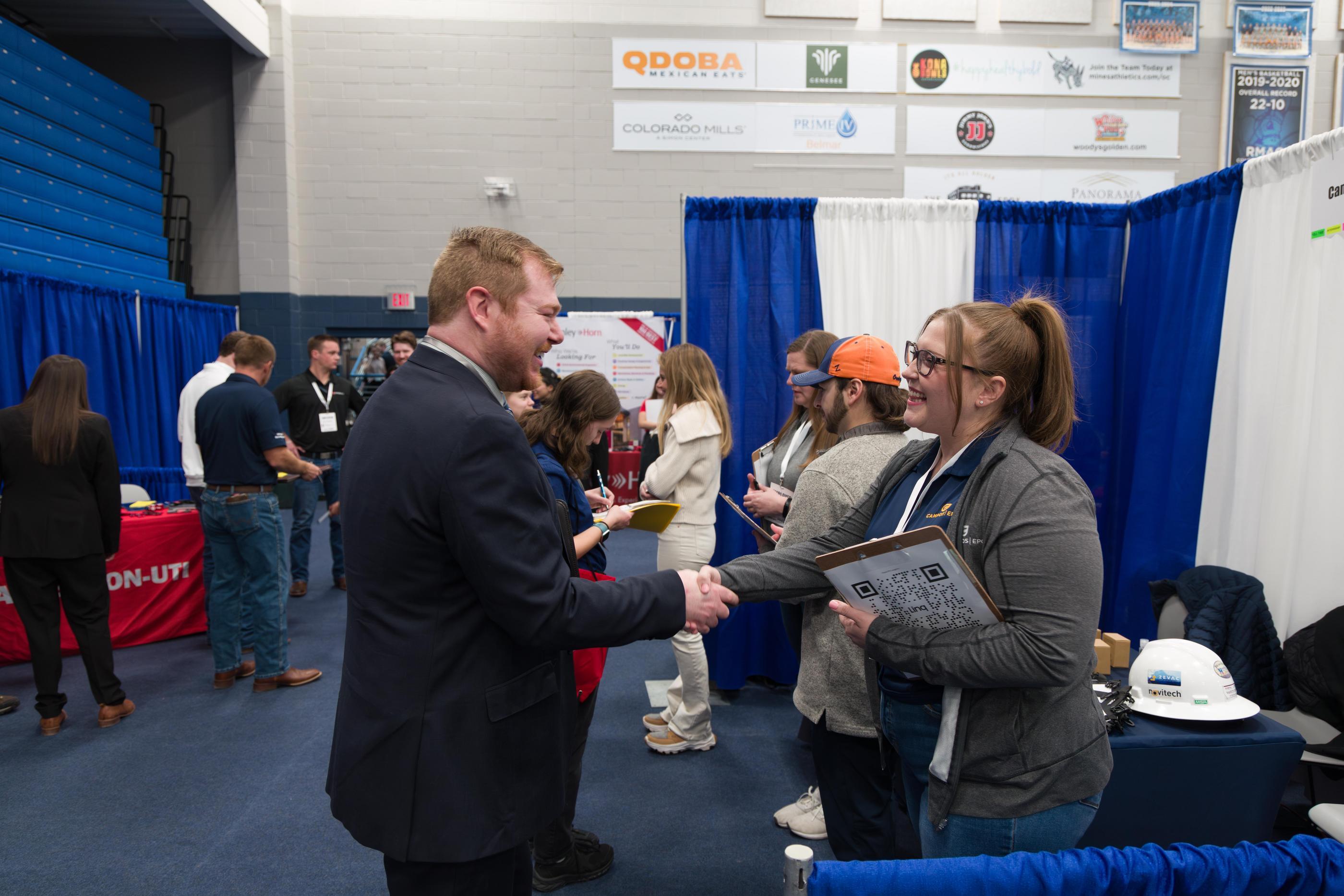 Students and recruiter shake hands at Career Days