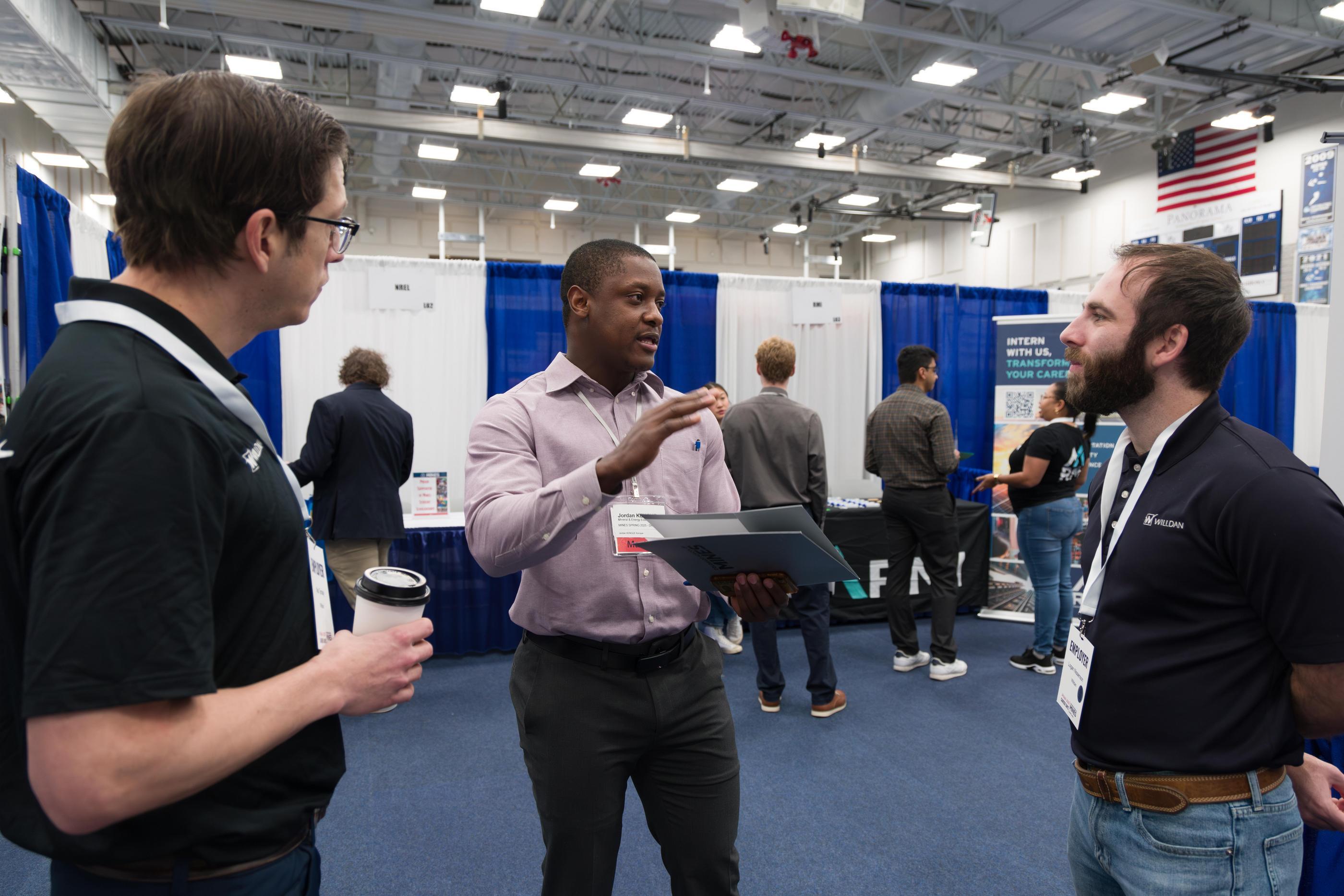 Jordan Kengue, a master's student in the Mineral & Energy Economics Program, center, speaks with recruiters from Wildan, a nationwide provider of professional, technical and consulting services to utilities, government agencies, and private industry. Career Days is a great opportunity for students of all majors to explore potential job opportunities in a wide variety of industries.