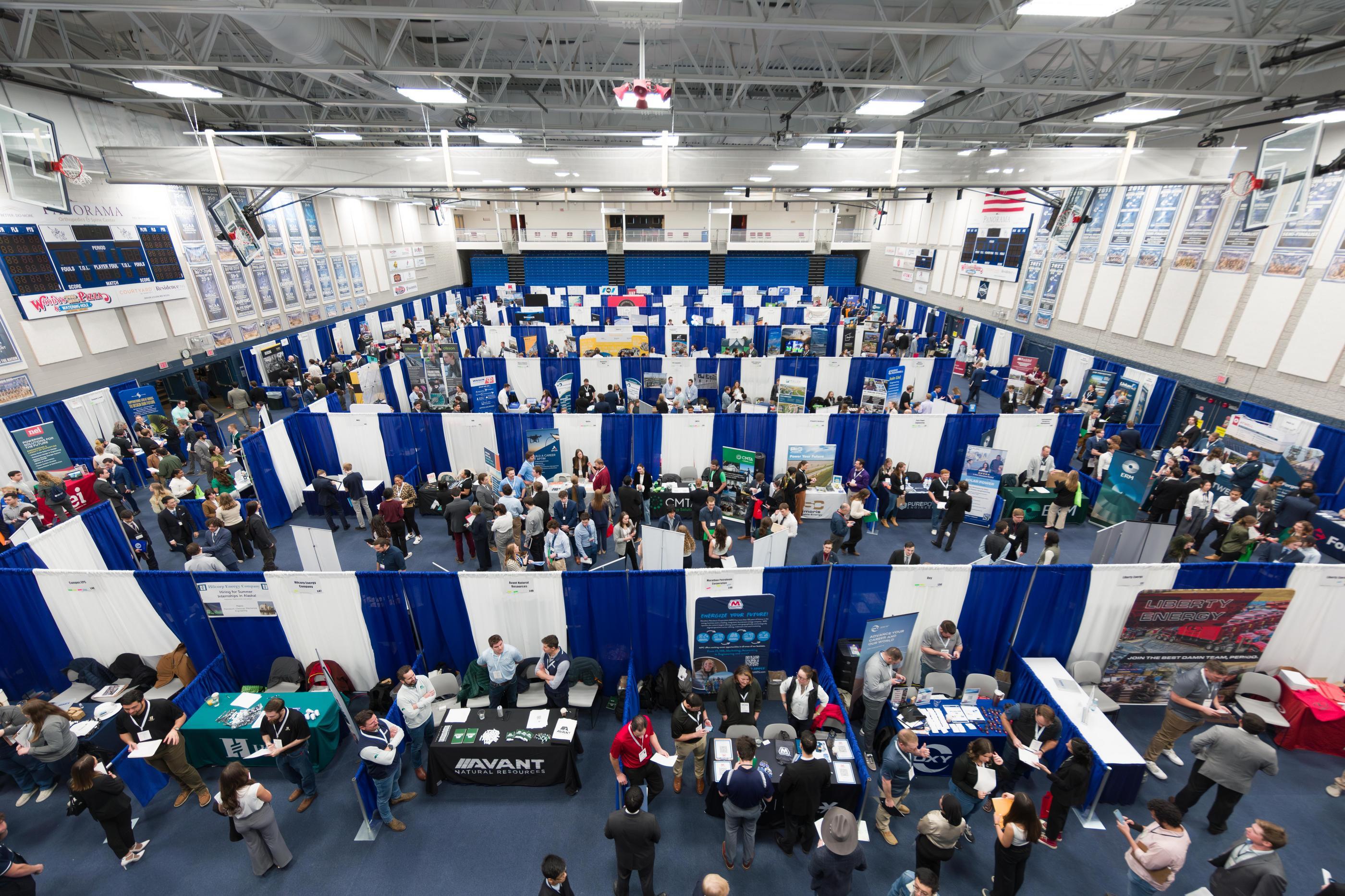 Bleachers view of the Mines Career Days career fair, with rows of employer booths filling the Rec Center gym floor.