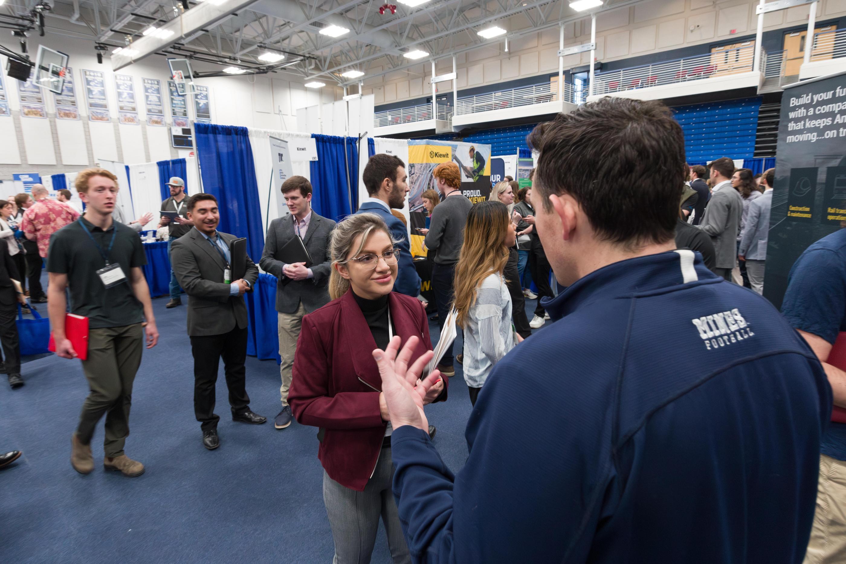 Mechanical engineering major Farima Molaei discusses career opportunities with John Andrew Zorn '16, a Mines Football alum recruiting for rail and heavy construction contractor Herzog. Many Mines alumni return to campus for Career Days — but this time as recruiters for their current employers.