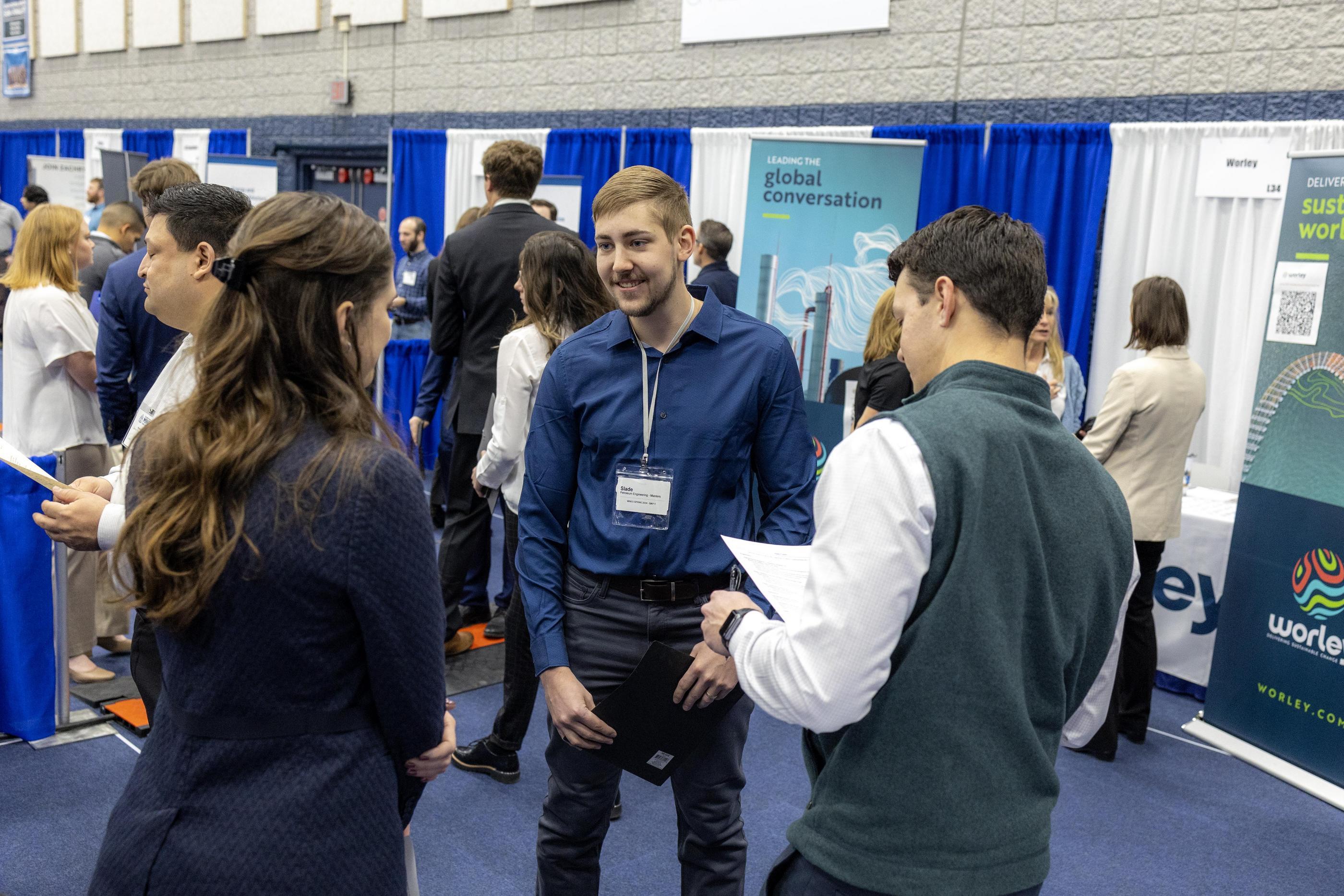 A student talks with two job recruiters