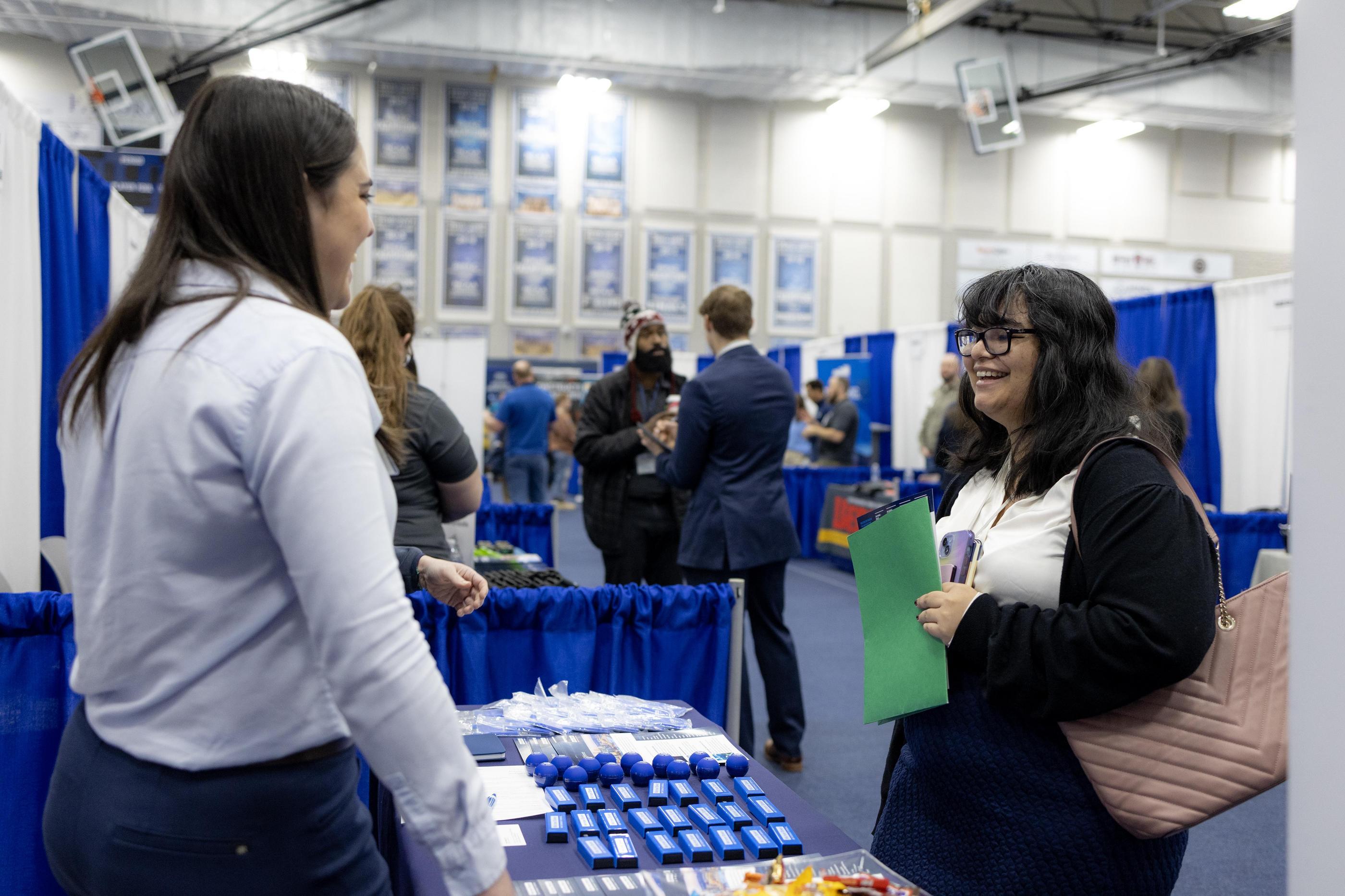 A student talks with a recruiter at a booth