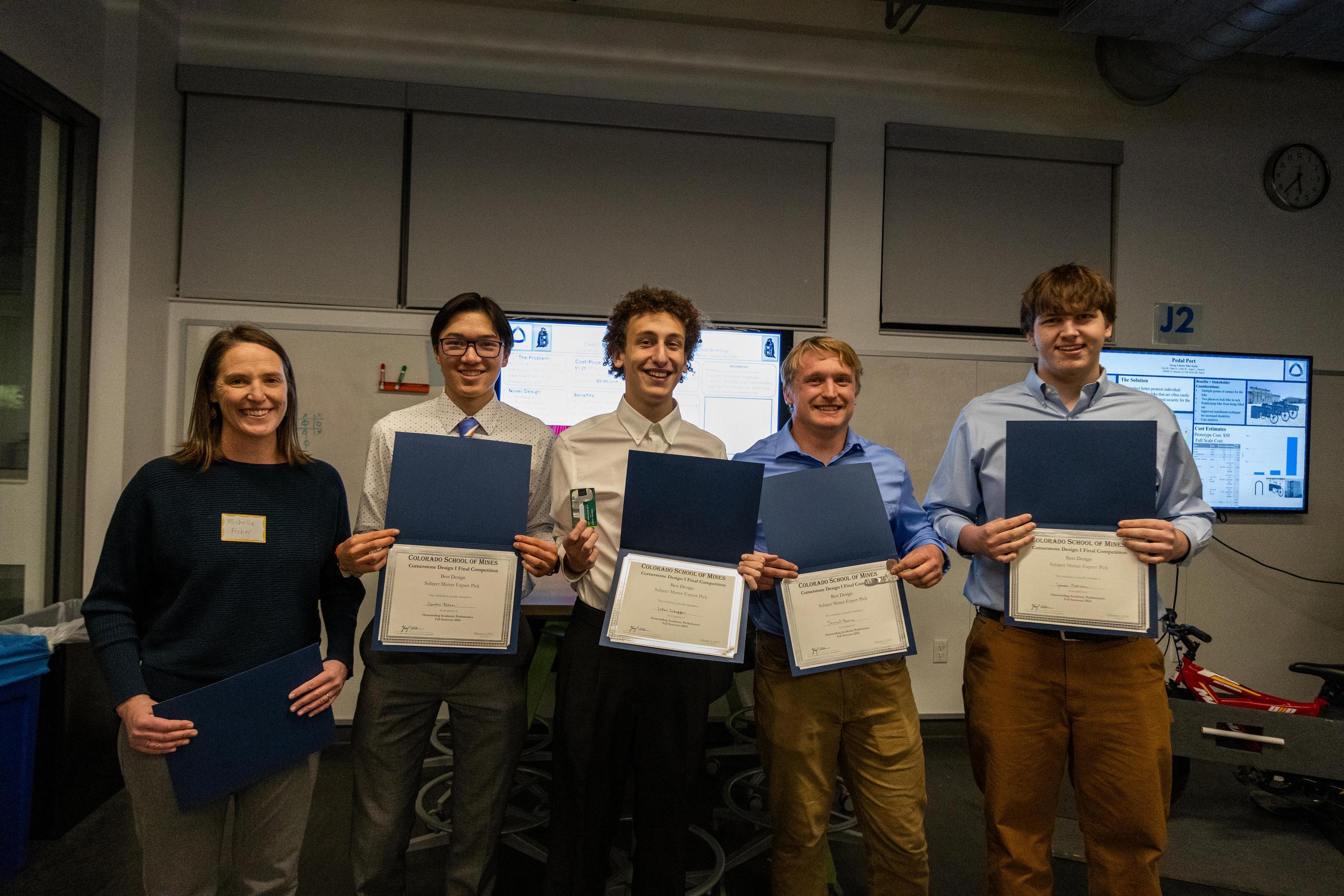A group of students pose with award certificates with their advisors
