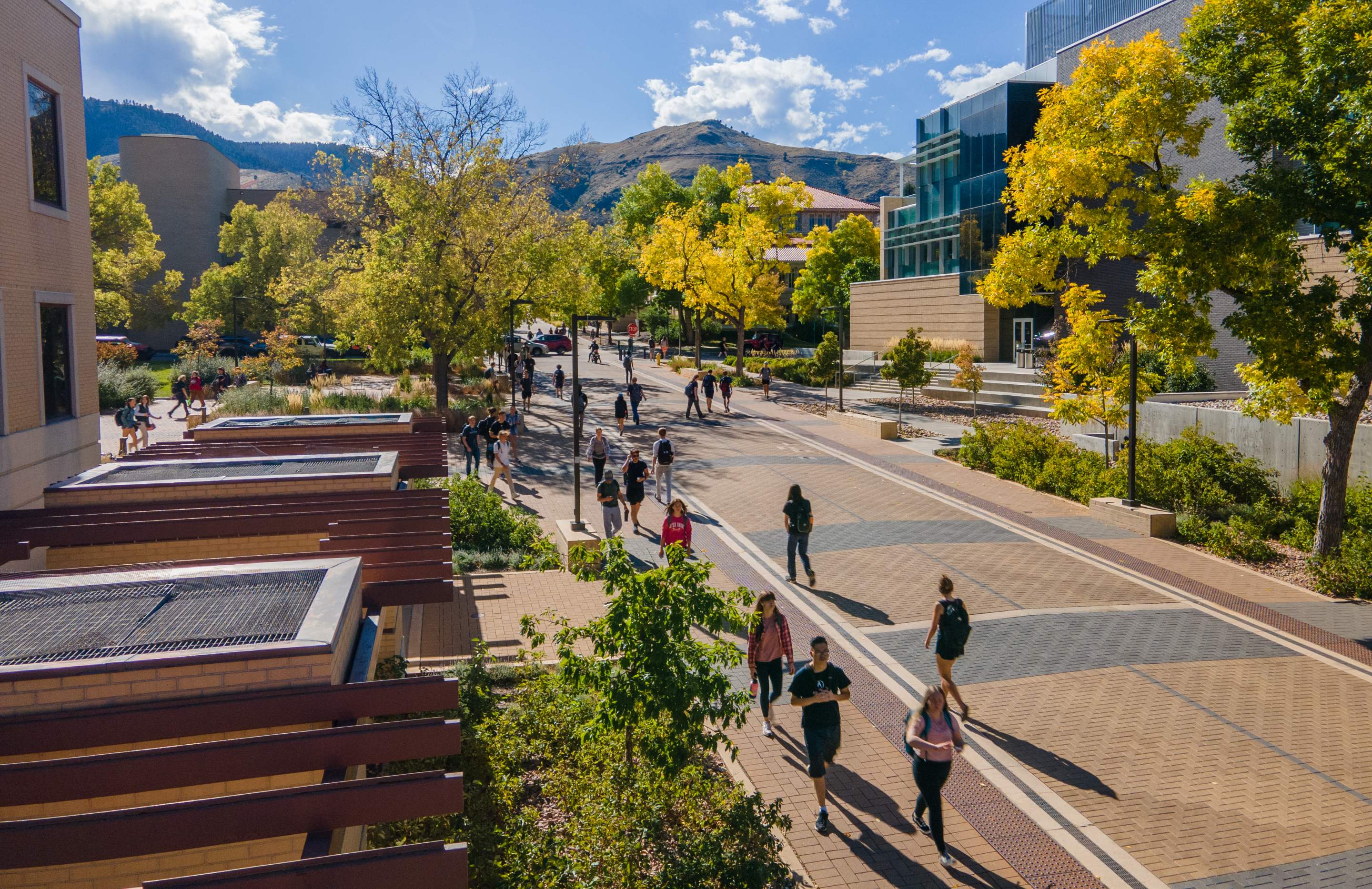 Mines students walk along a campus plaza walkway in the fall.