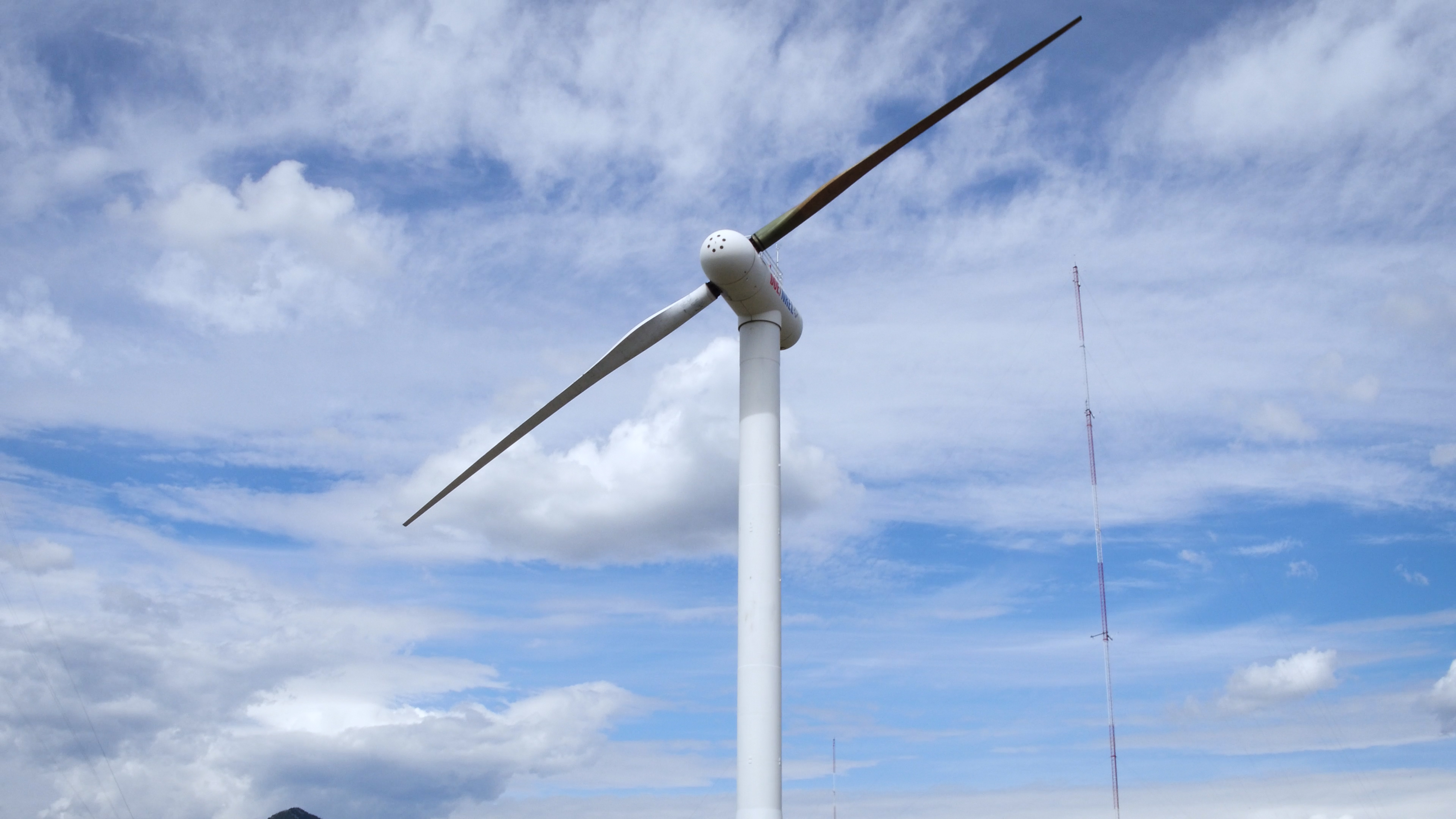 wind turbine against blue and white sky