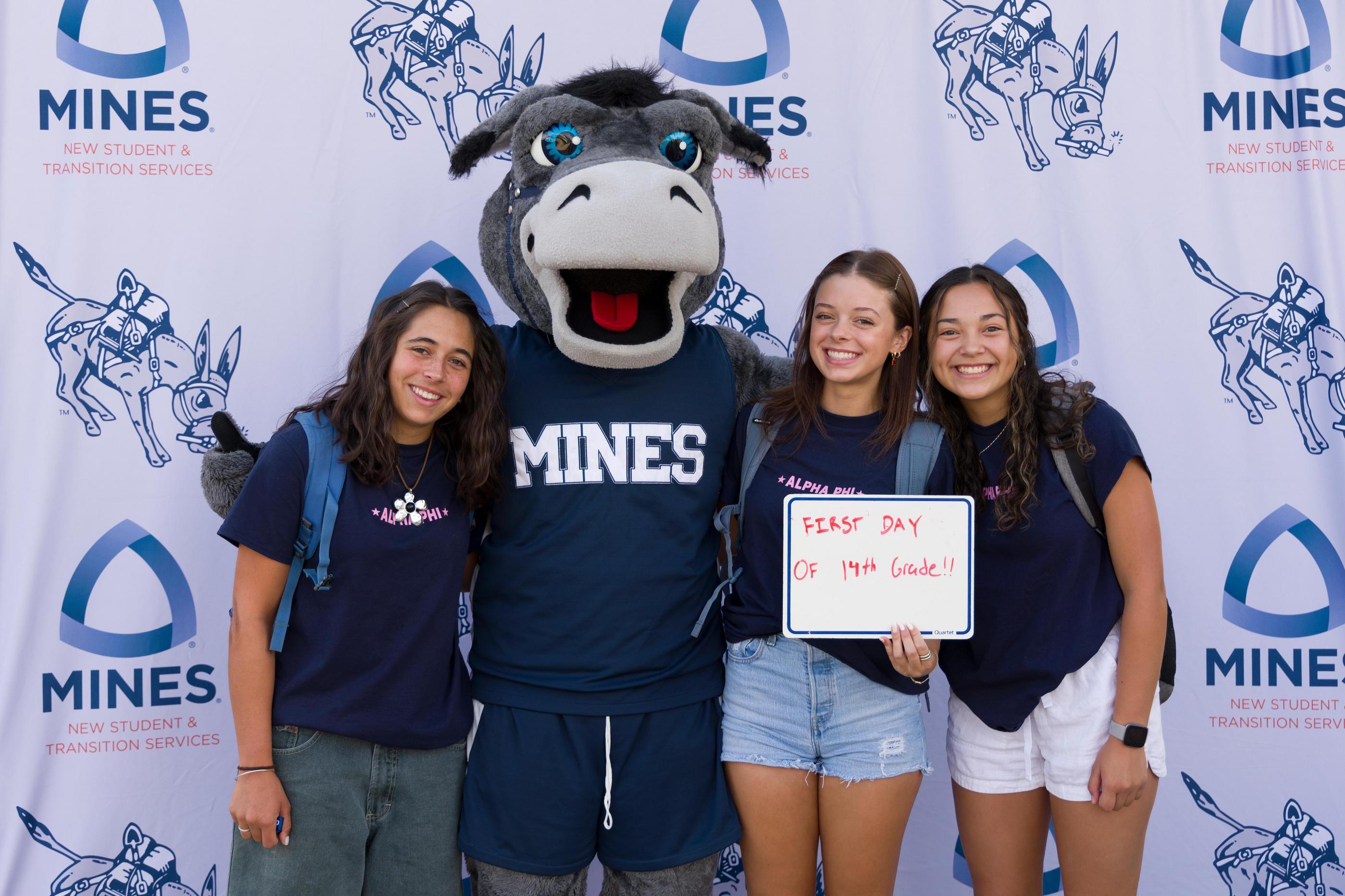 three female students pose with Blaster the Burro