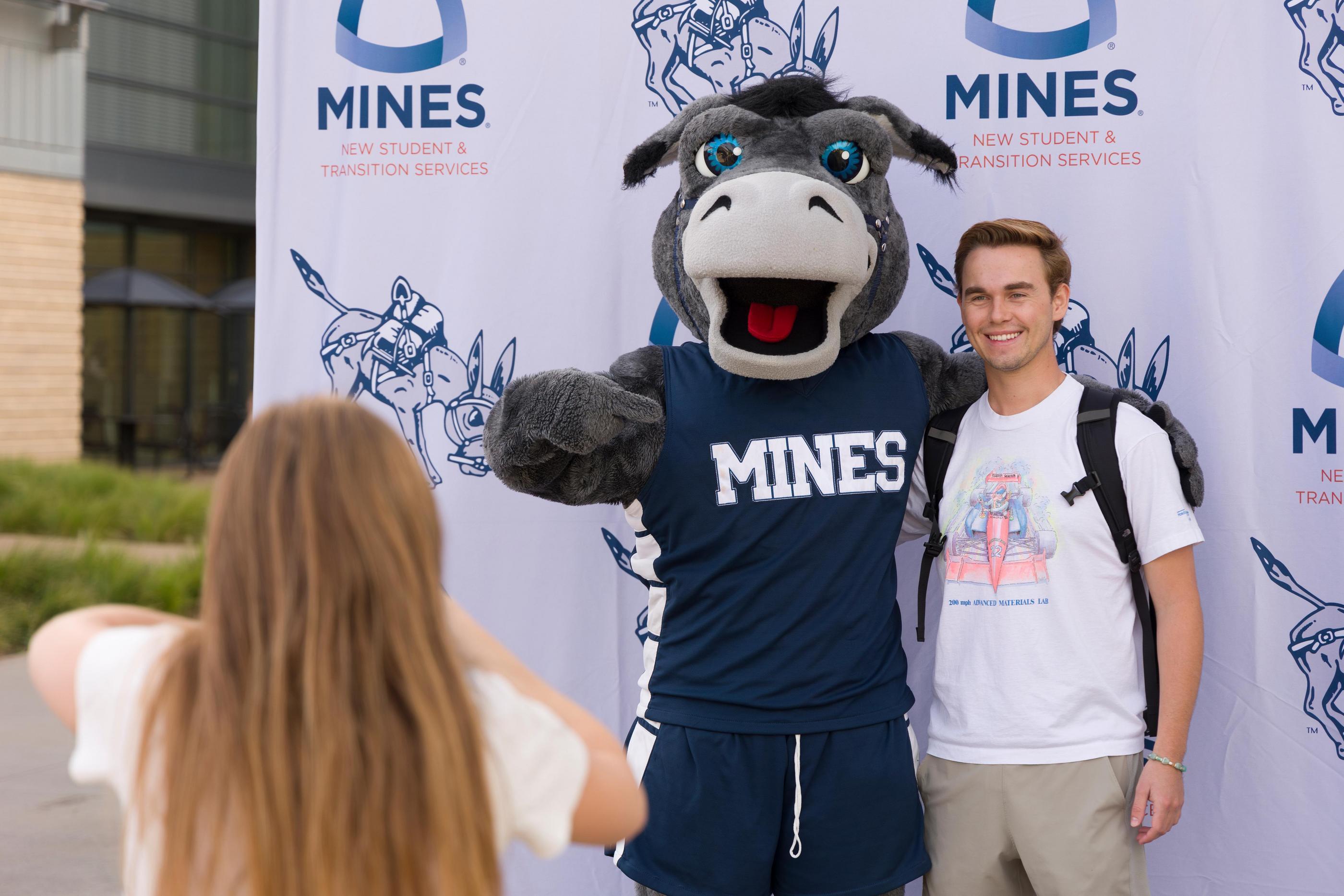 A student poses for a picture with Blaster the mascot