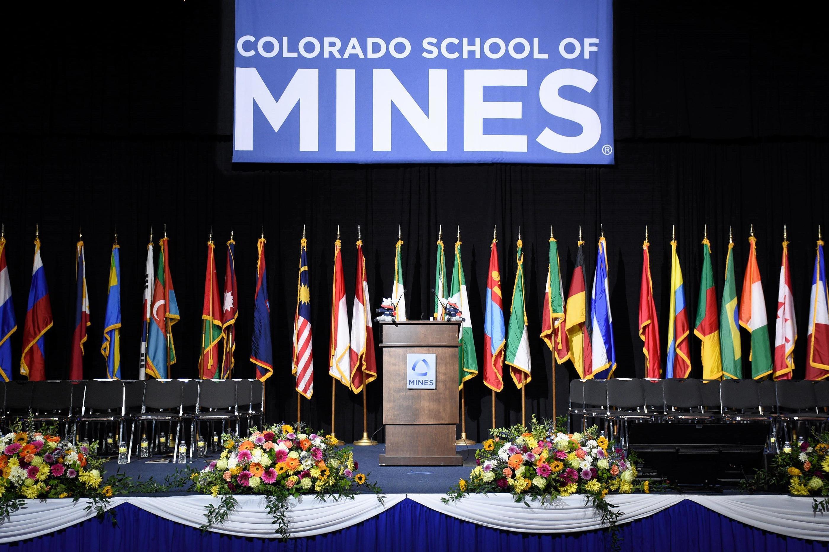 A podium sits in the middle of the Commencement stage with flags behind it