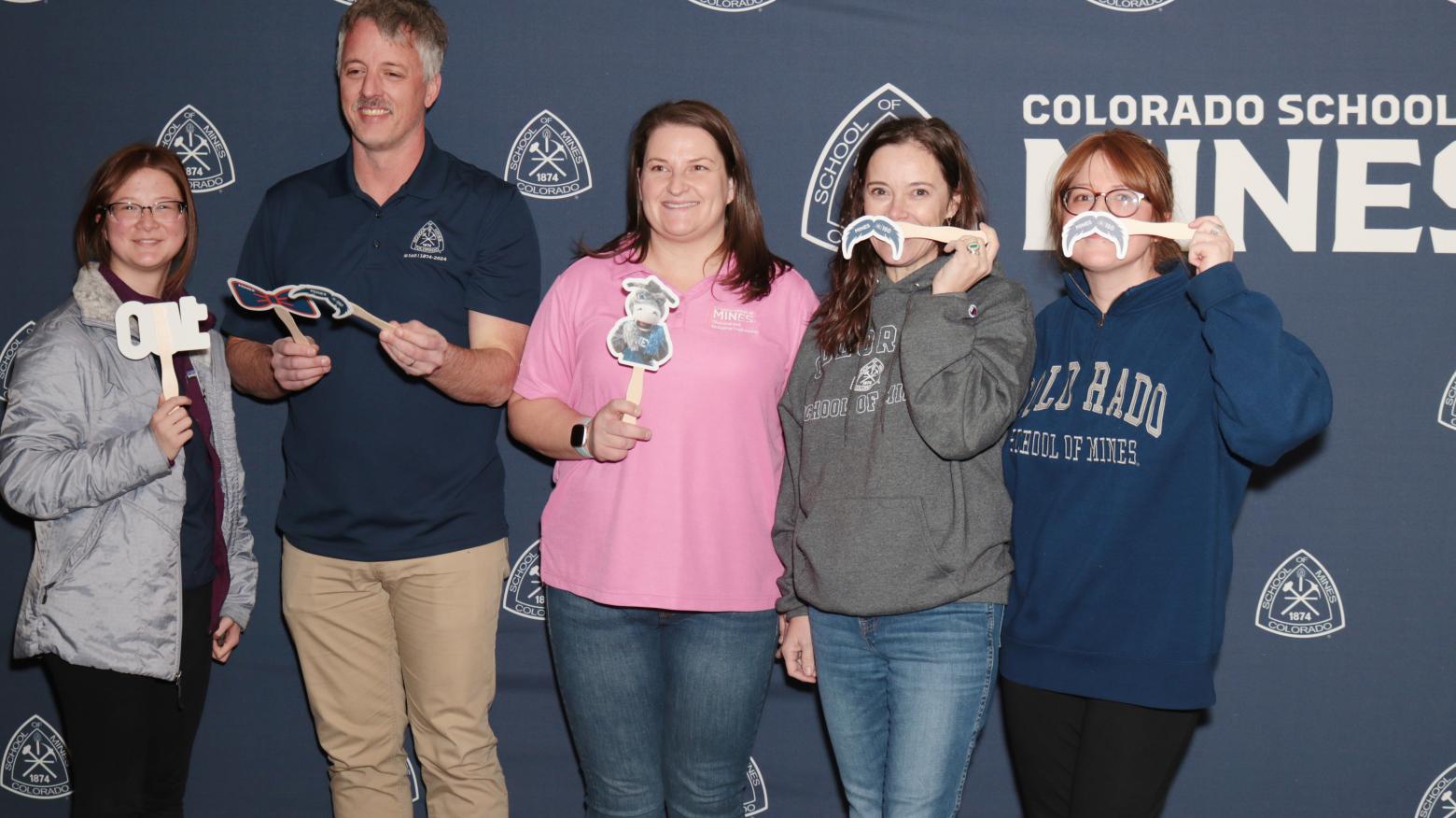 Group of Mines faculty pose with photo props