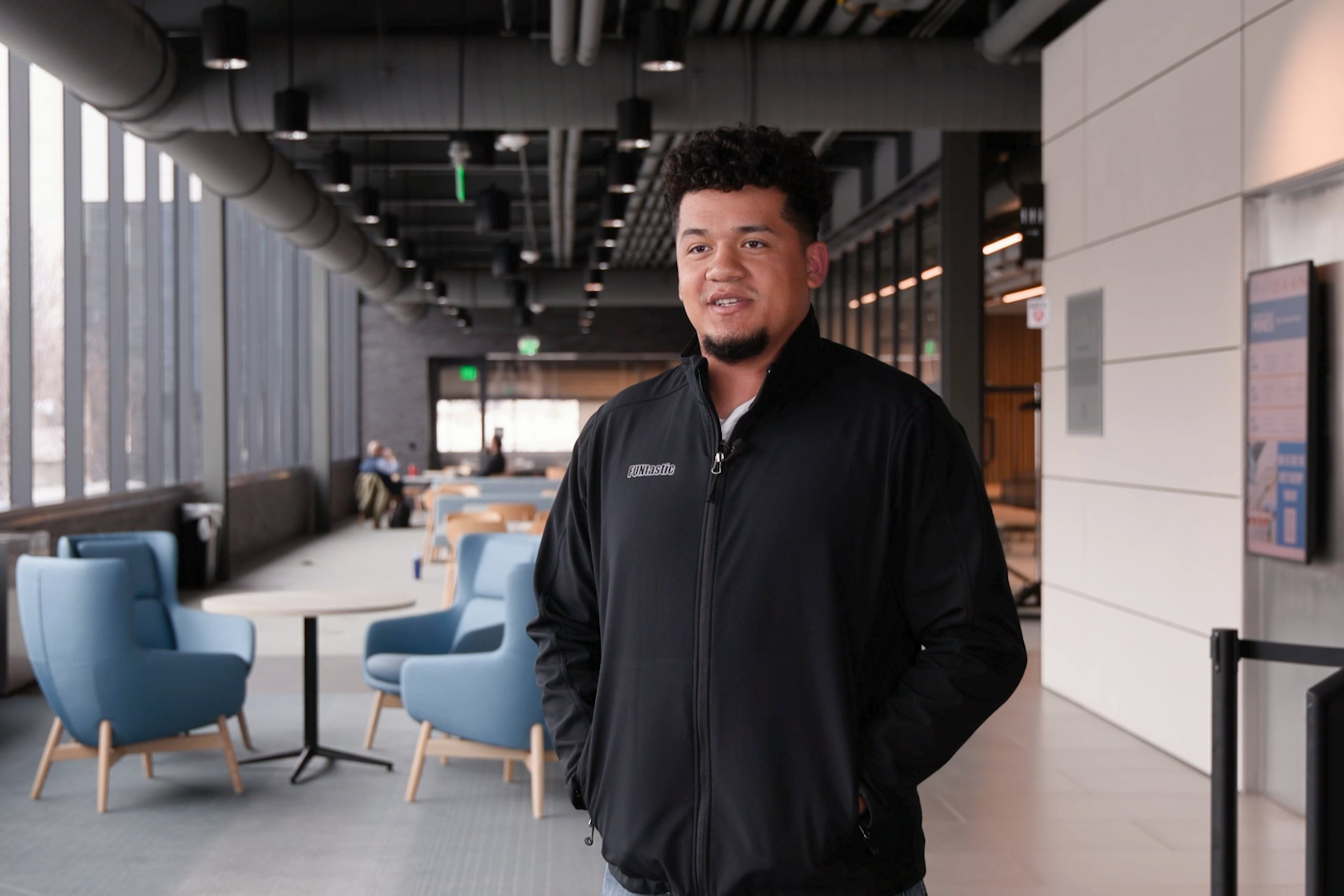 Jalen Thomas, founder of FUNtastic, stands in a Colorado School of Mines building wearing a black jacket with the FUNtastic logo.