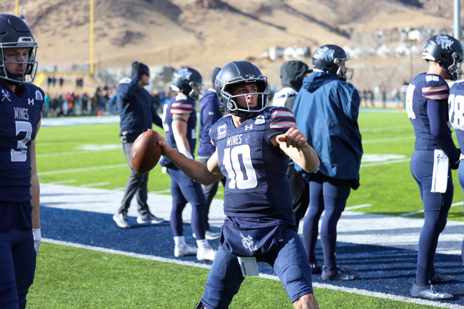 Mines Football Quarterback John Matocha throws a football on the field during practice.