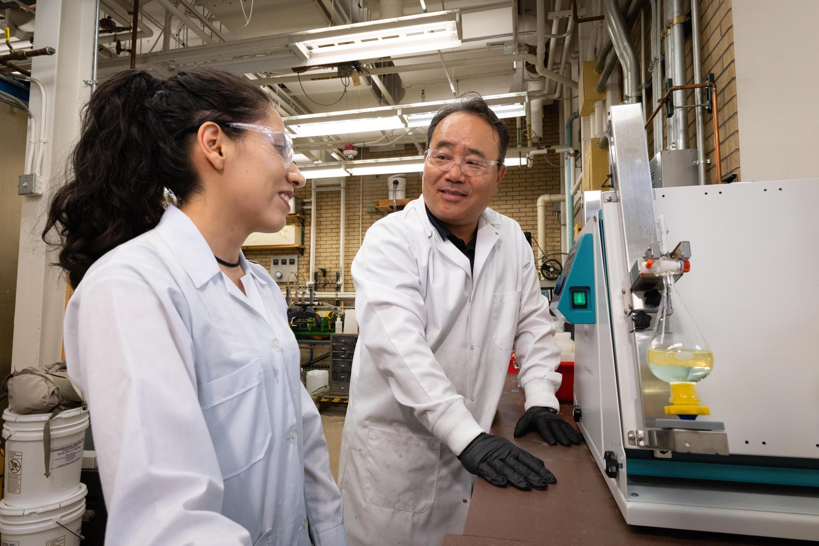Jaeheon Lee talks with a student researcher in the lab