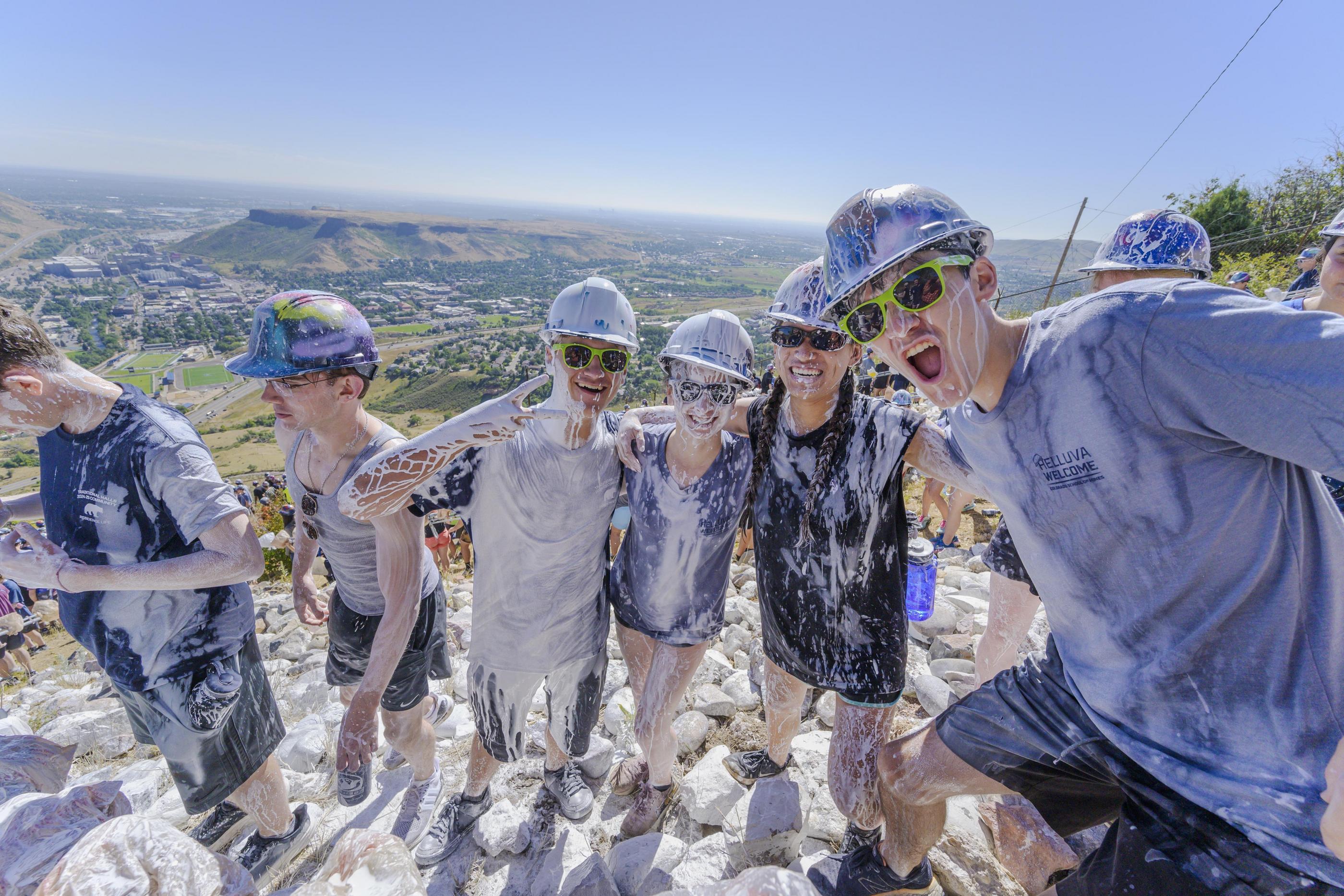 Students covered in white wash pose for a photo on Mount Zion during the M Climb.
