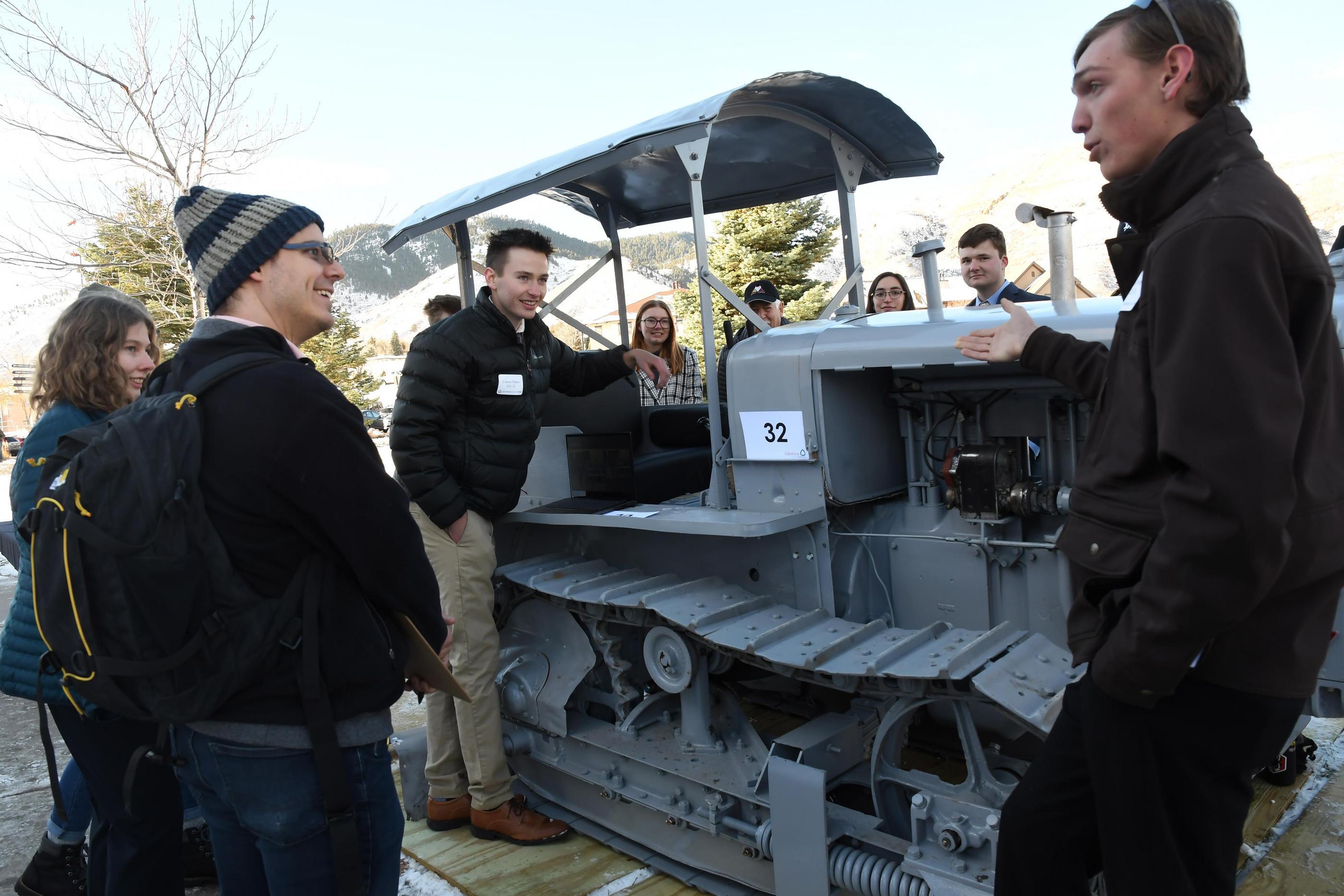 Students stand next to a restored 1927 Caterpillar Crawler Tractor