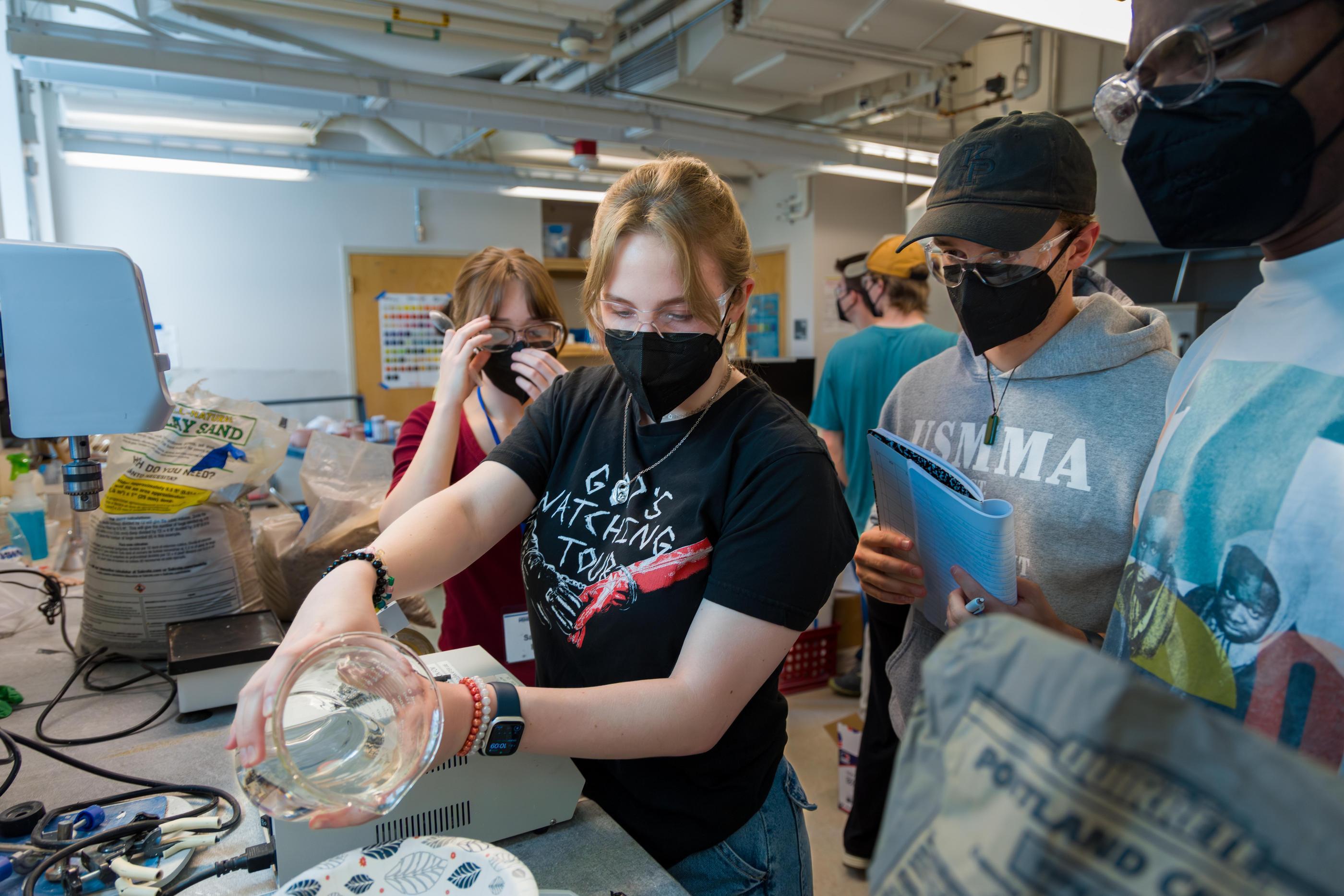 Students wearing masks experiment with concrete mixes in lab