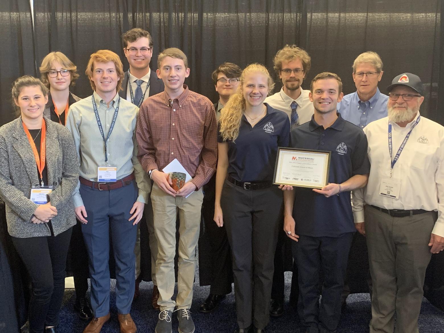A group of students pose with a certificate and award
